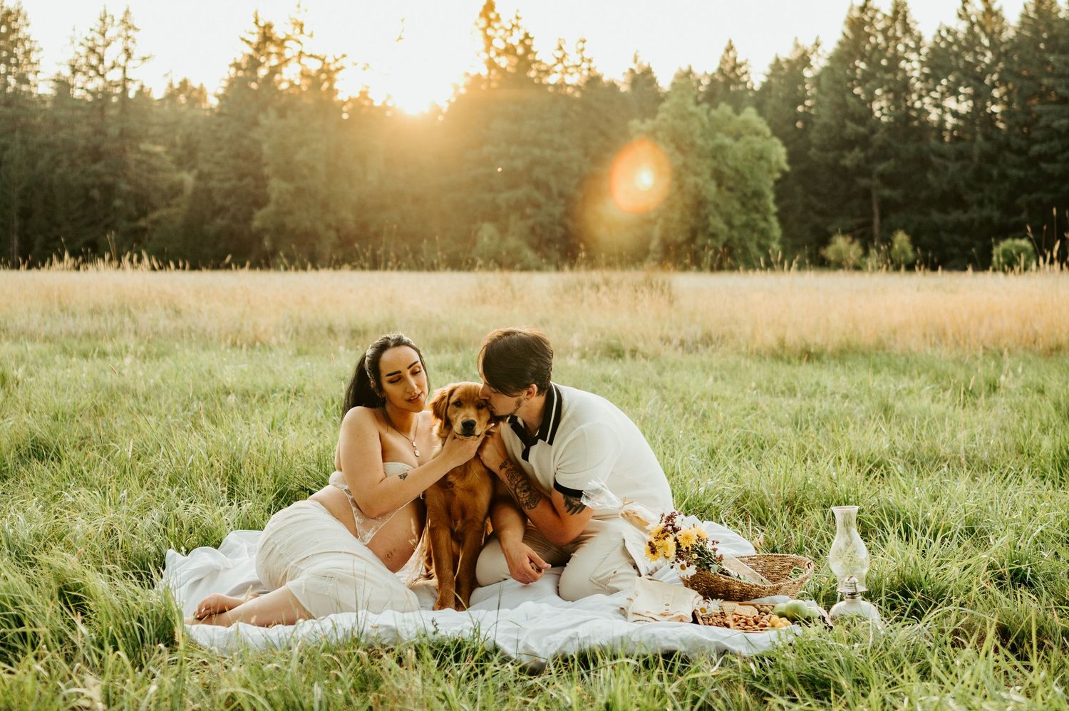 A romantic sunset picnic scene set up in a grassy meadow with golden light filtering through trees.