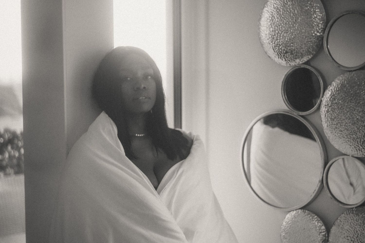 A woman wrapped in a blanket – an emotional moment from a boudoir photoshoot.