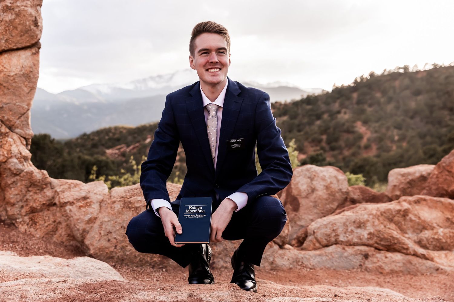 Young LDS missionary holding Book of Mormon and Polish flag during photo session by New Castle, Indiana photographer