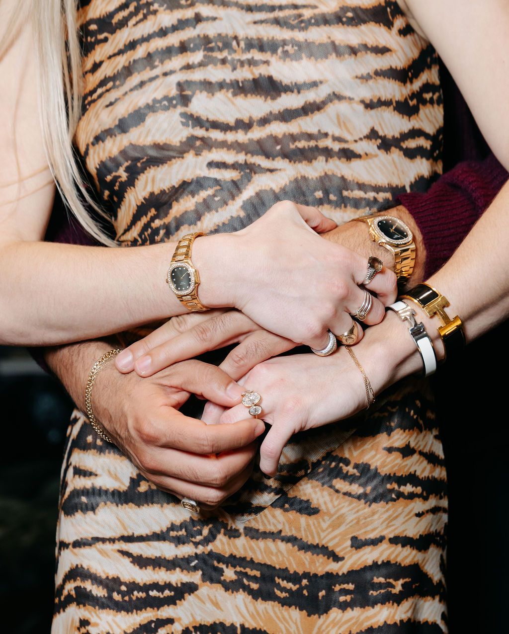 A series of photos showing hands wearing gold rings and jewelry against a tiger print fabric background.