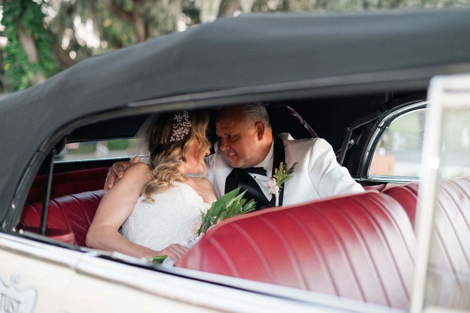 Wedding guests gather under trees at an elegant outdoor venue during sunset celebrations.