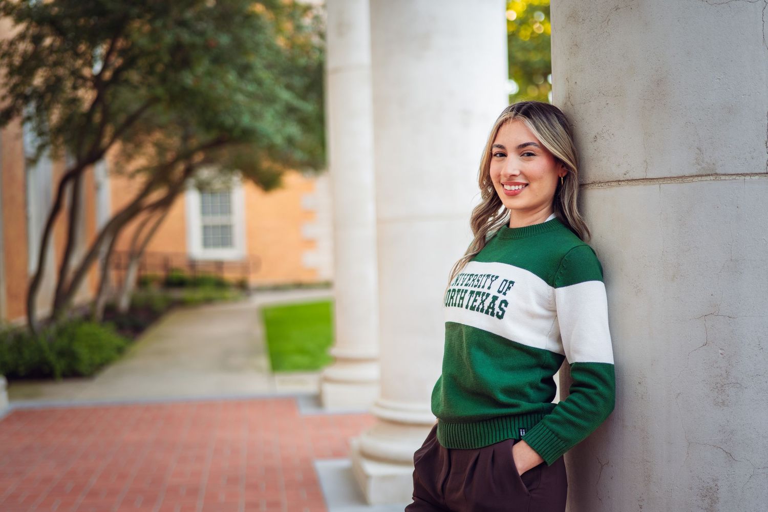 College Graduate smiling at the camera during her DFW Graduate Portrait Photoshoot by Eric Aaberg Photography.