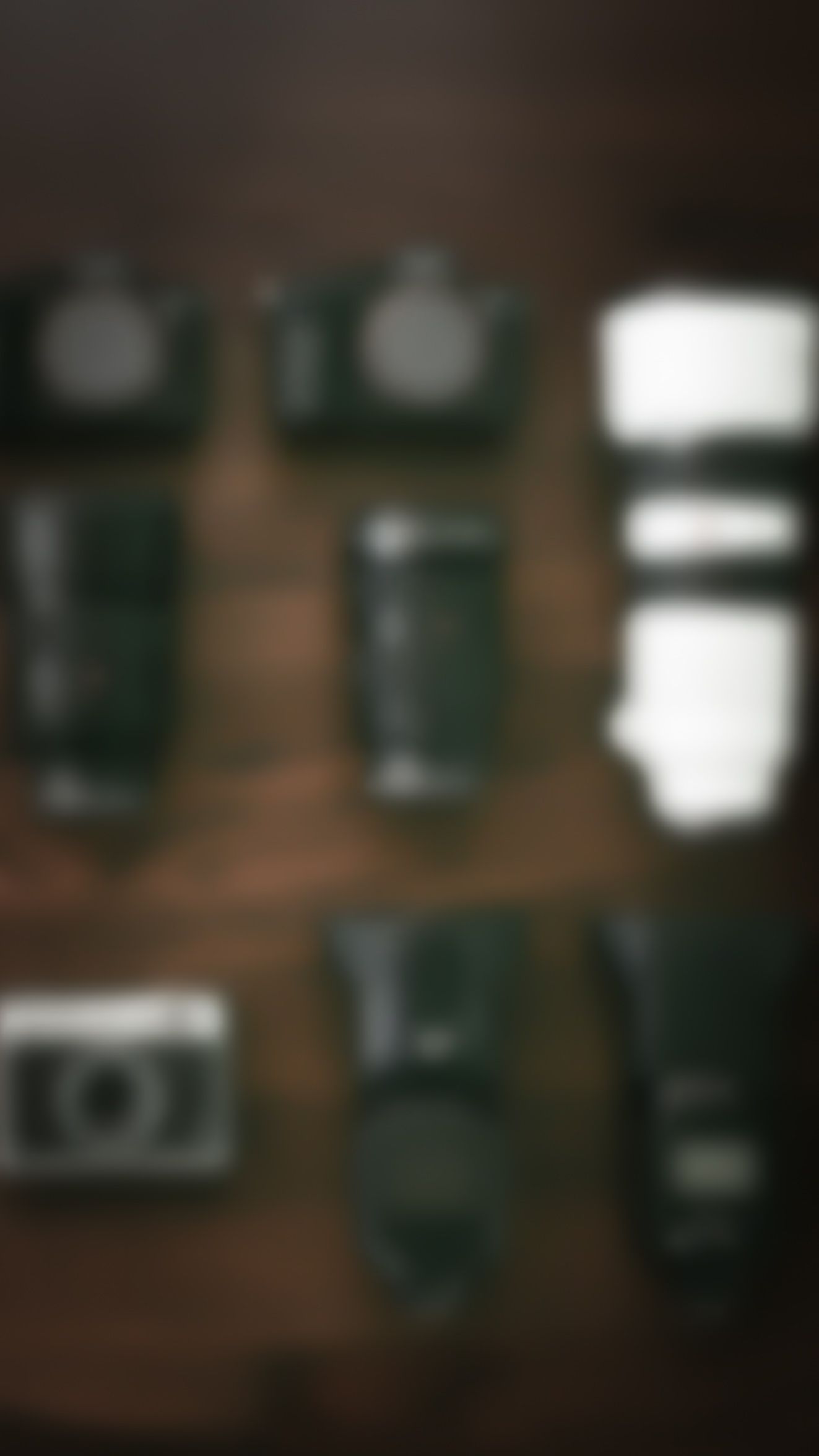 A blurry collection of vintage cameras displayed on a wooden surface.