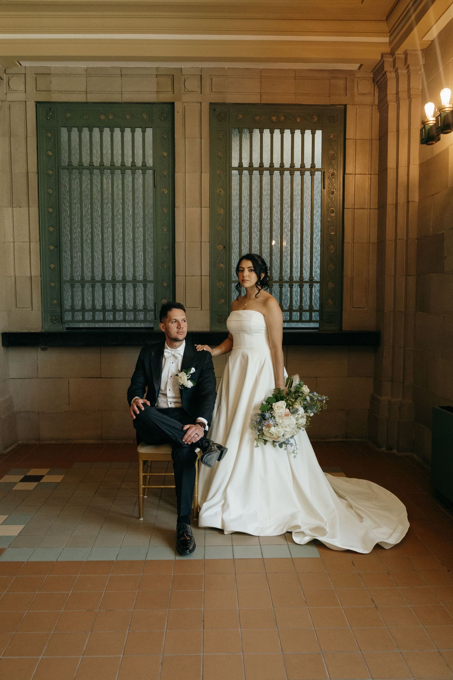 A romantic candid moment shared between newlyweds at their wedding, with delicate white flowers and formal attire.