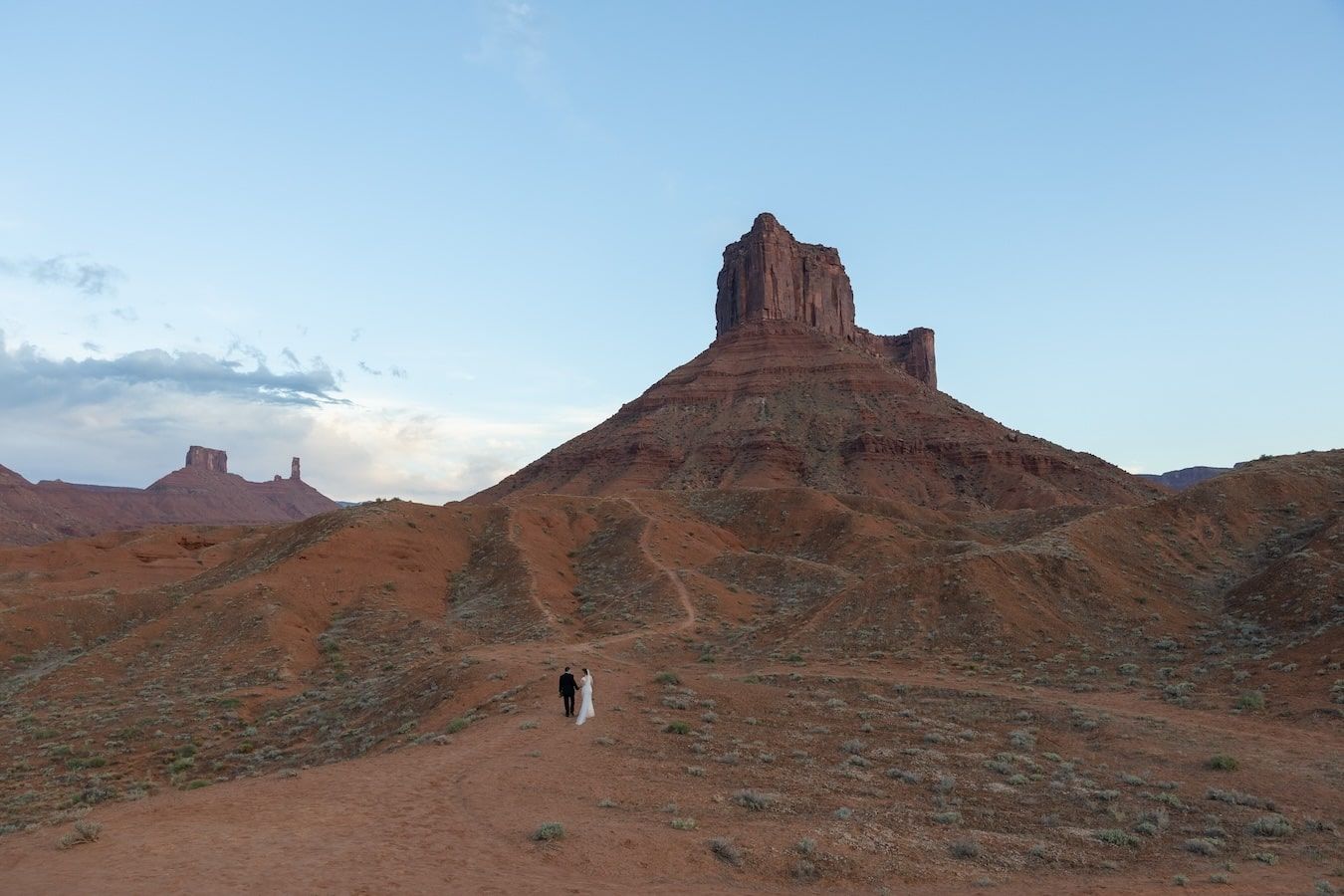 just married couple is climbing a butte in Utah