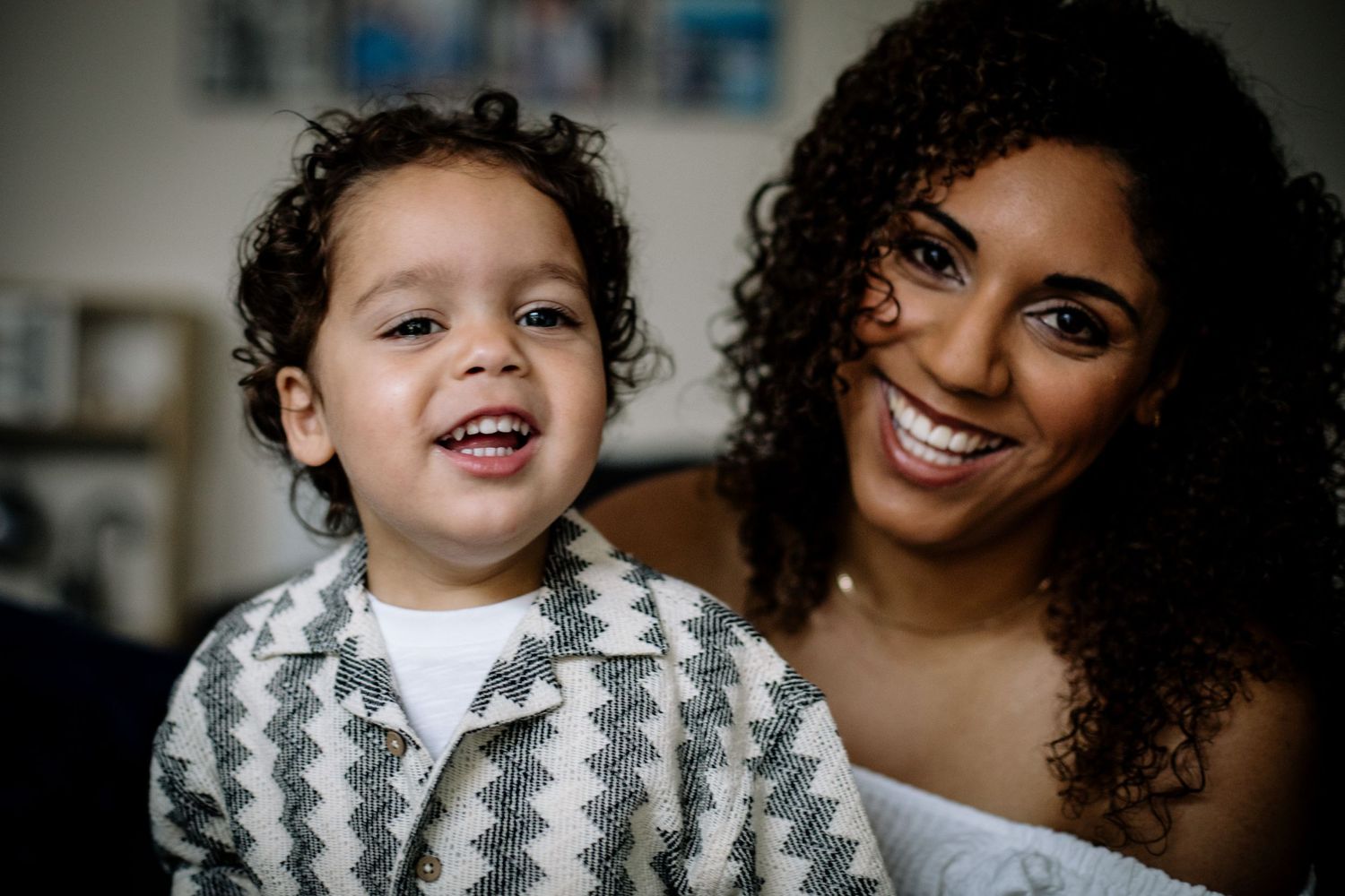 A joyful moment captured between parent and child sharing bright smiles together indoors.