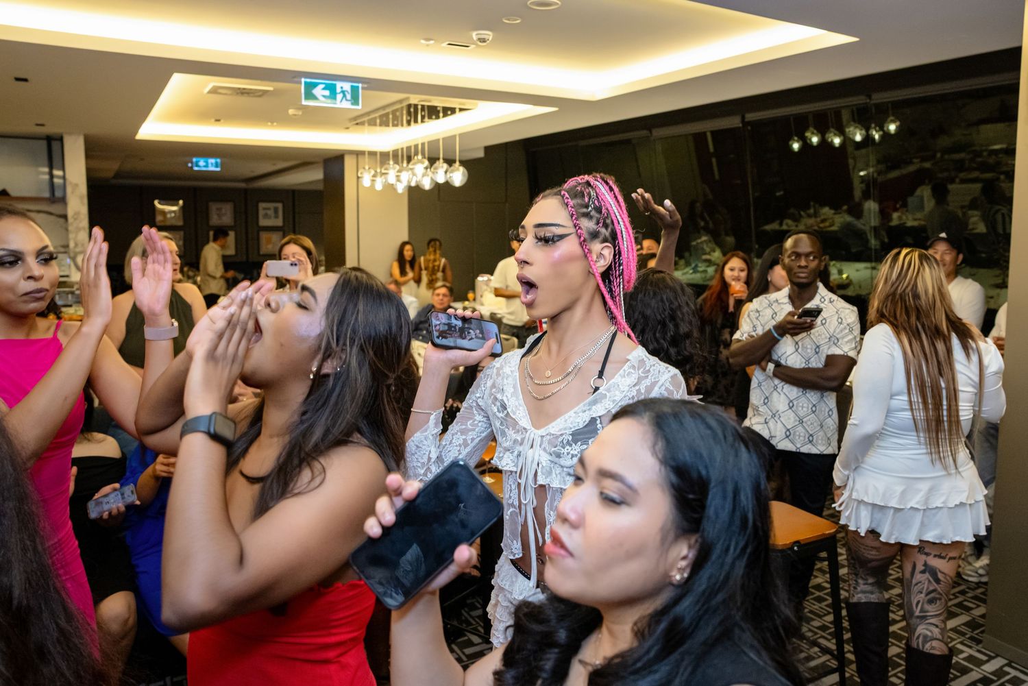 People enjoying shots of liquor at a lively indoor party or celebration event.