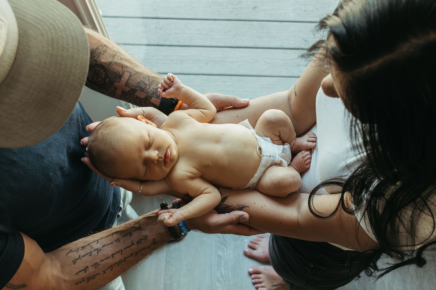 A series of connected images showing a baby receiving a gentle massage on a soft white surface.