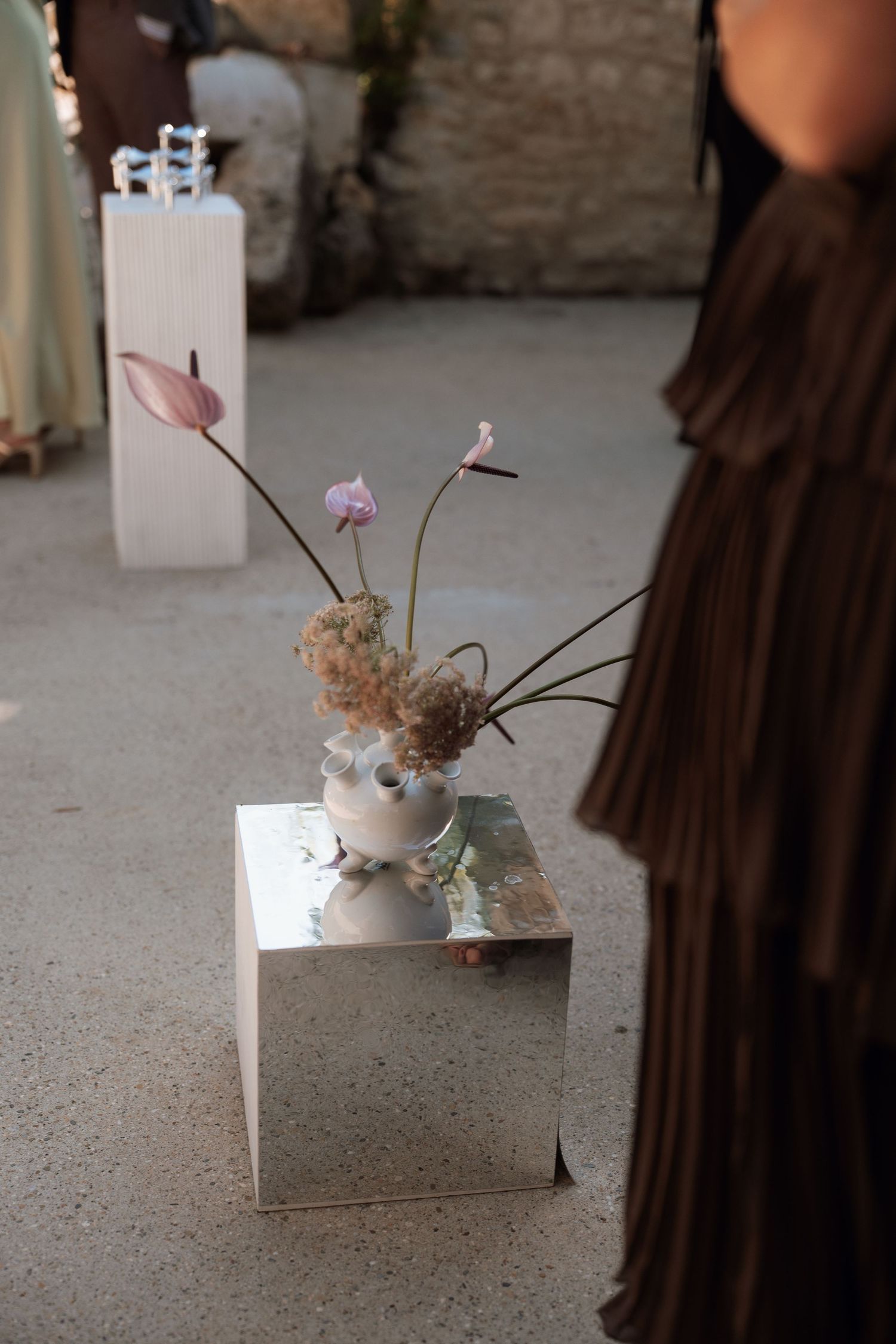 A series of four sequential images showing a small pink flower arrangement on a white box against a concrete floor.