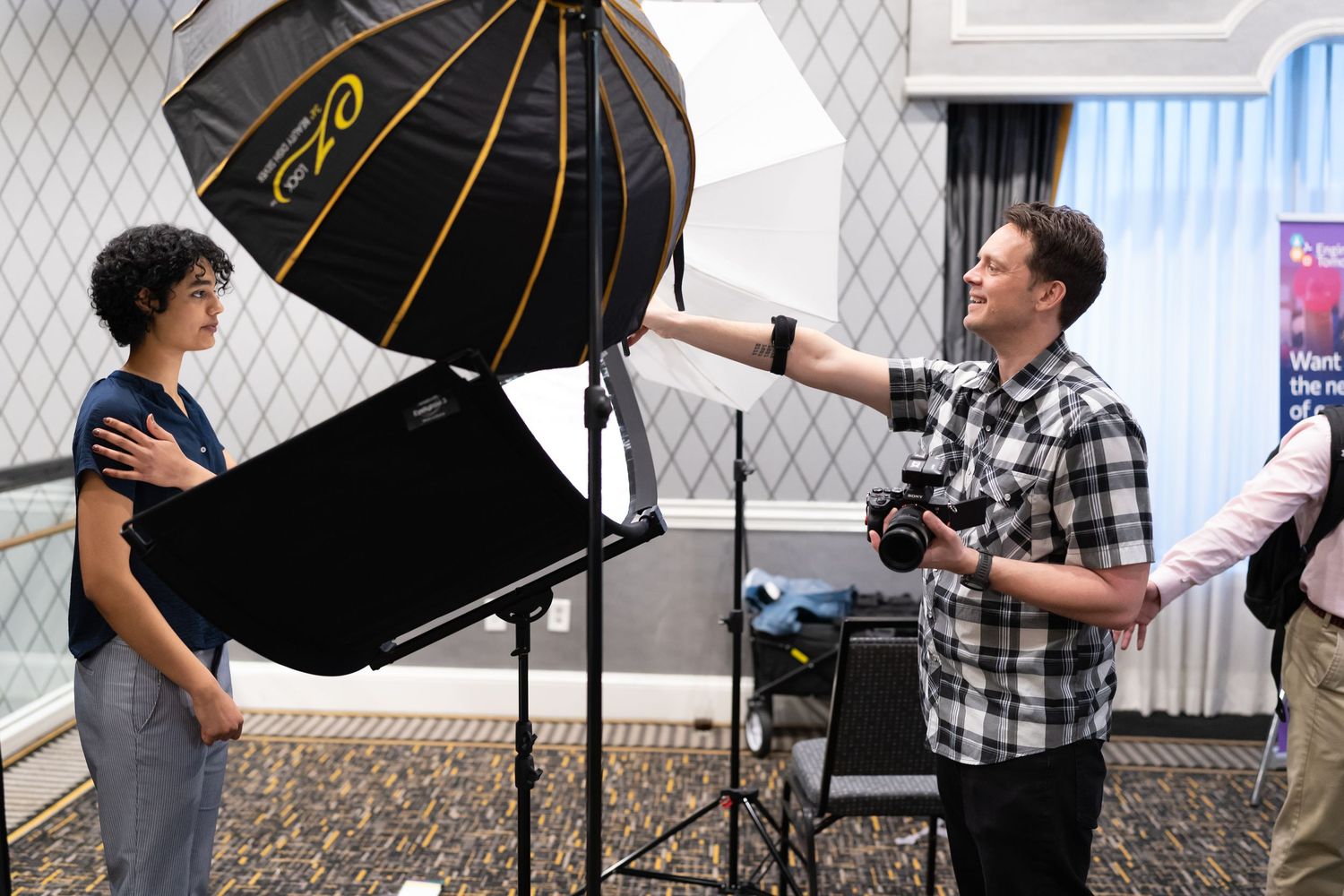 Behind the scenes photo shoot setup showing multiple studio lights and photography equipment in an indoor space.