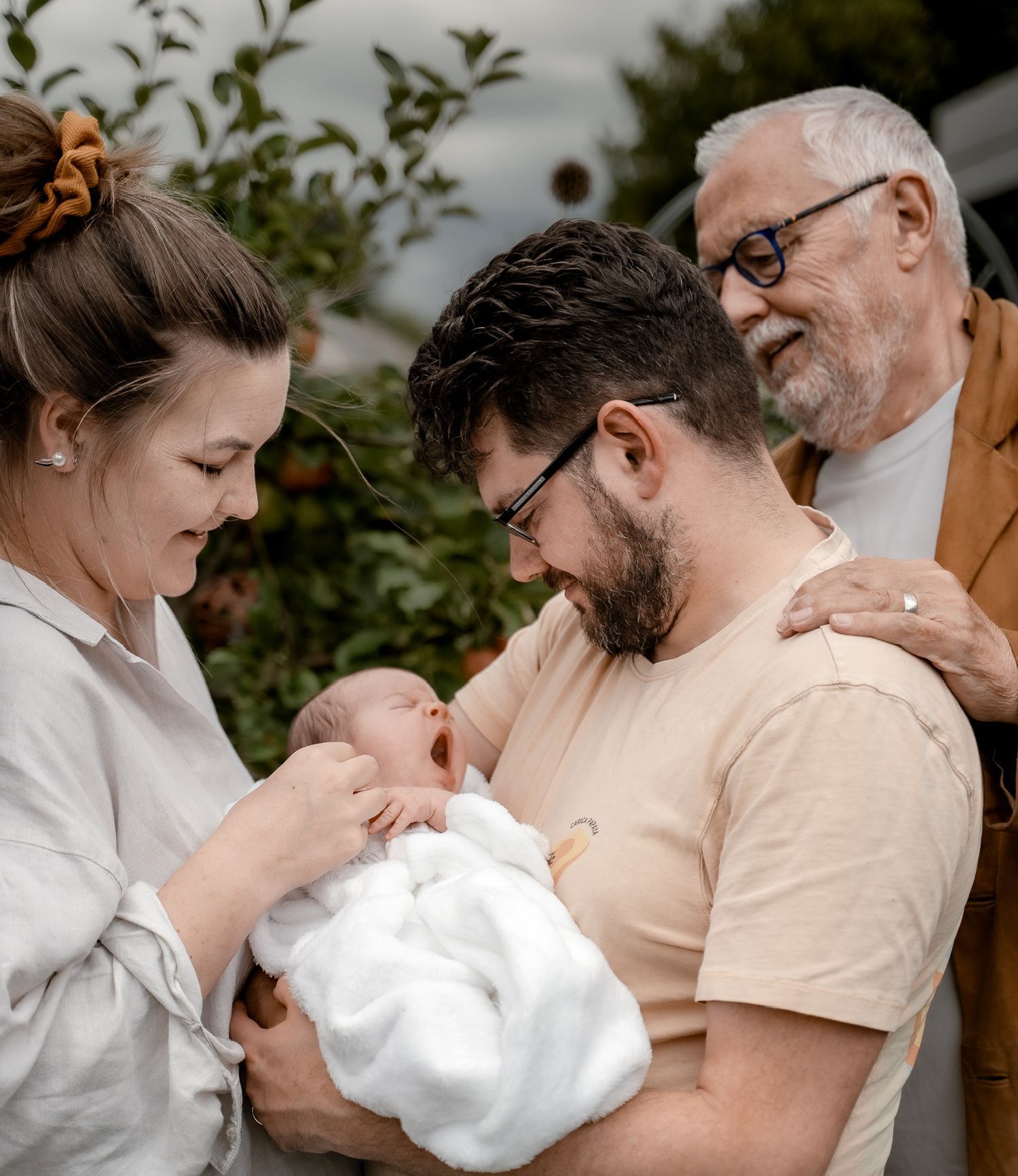 A tender family moment captured  showing parents holding their newborn baby.