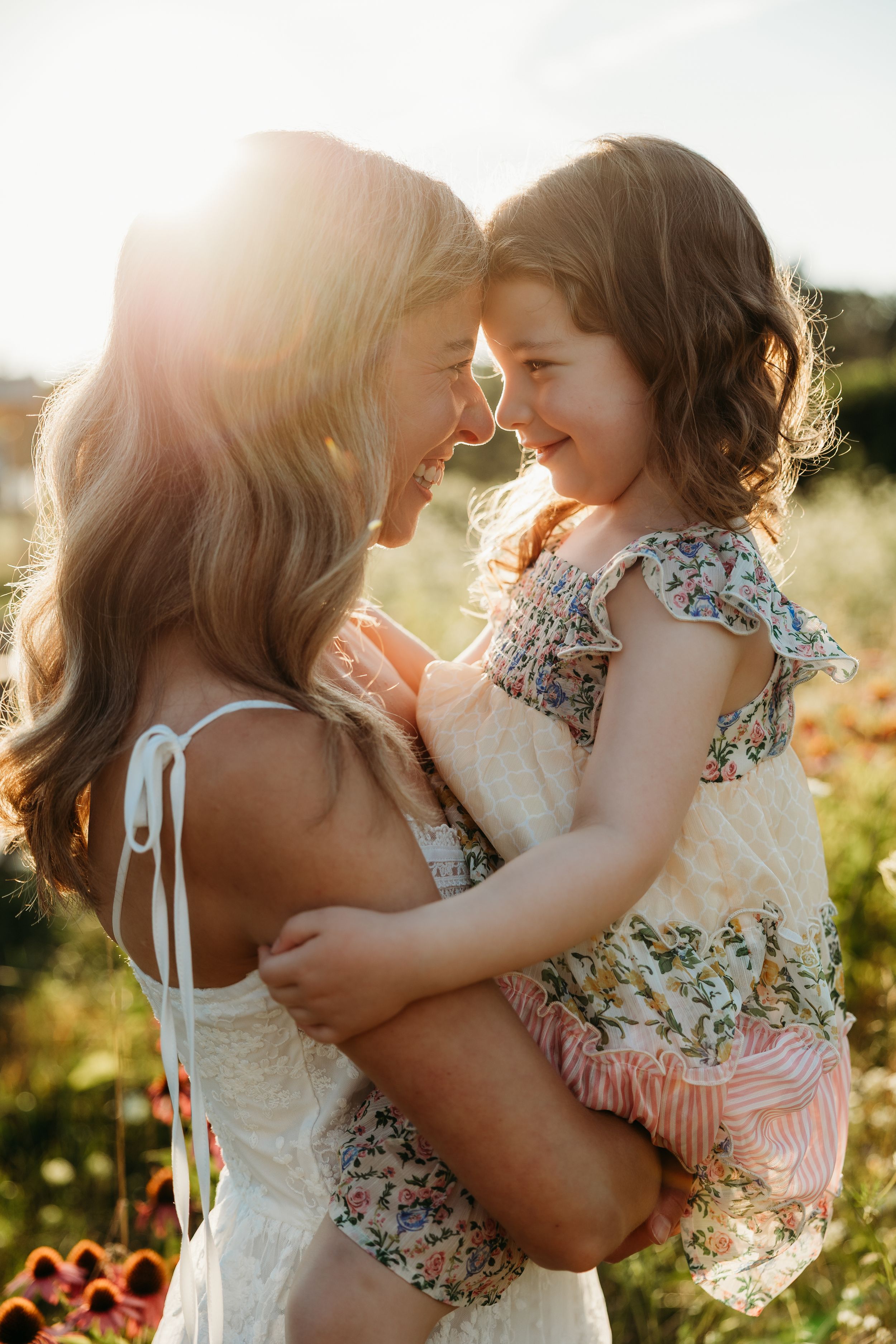 A young girl twirls in a floral dress in a sunlit meadow, her hair flowing freely in the golden light.