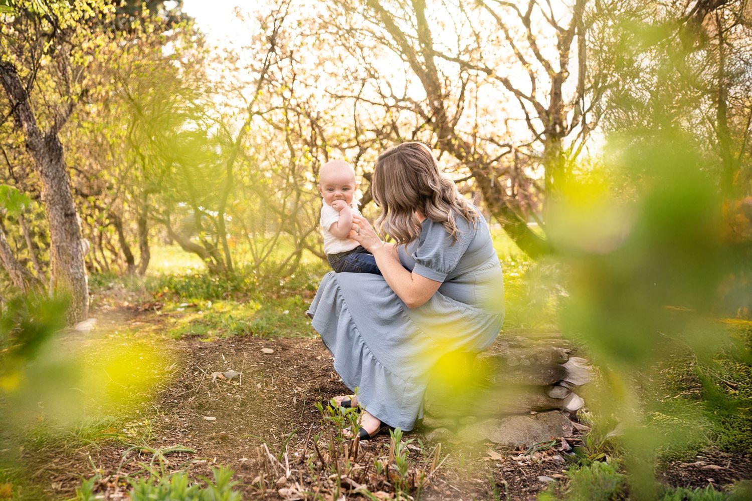 A photographer captures dreamy golden hour portraits in a sunlit forest setting with soft natural lighting.