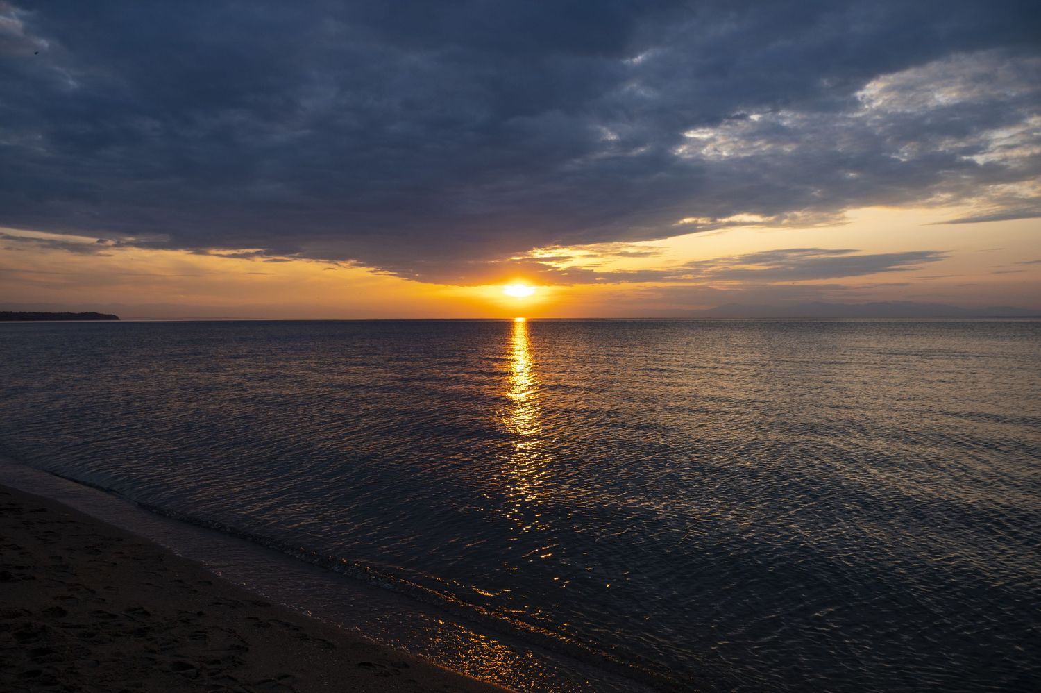 Stunning panoramic sequence of a vibrant ocean sunset with dramatic clouds reflecting on calm waters at dusk.