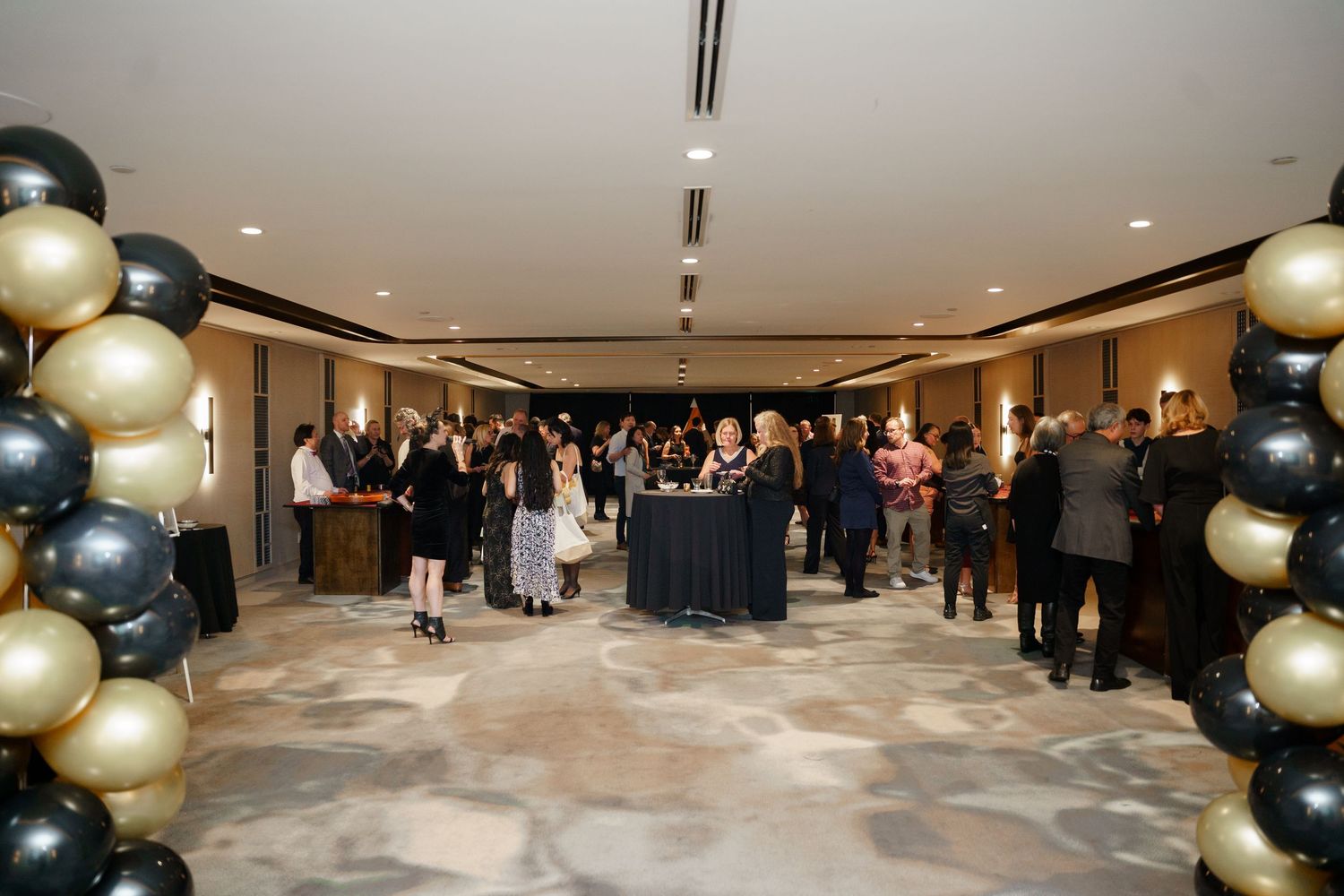 Ballroom event space decorated with elegant white fog effects and large metallic balloon arrangements.