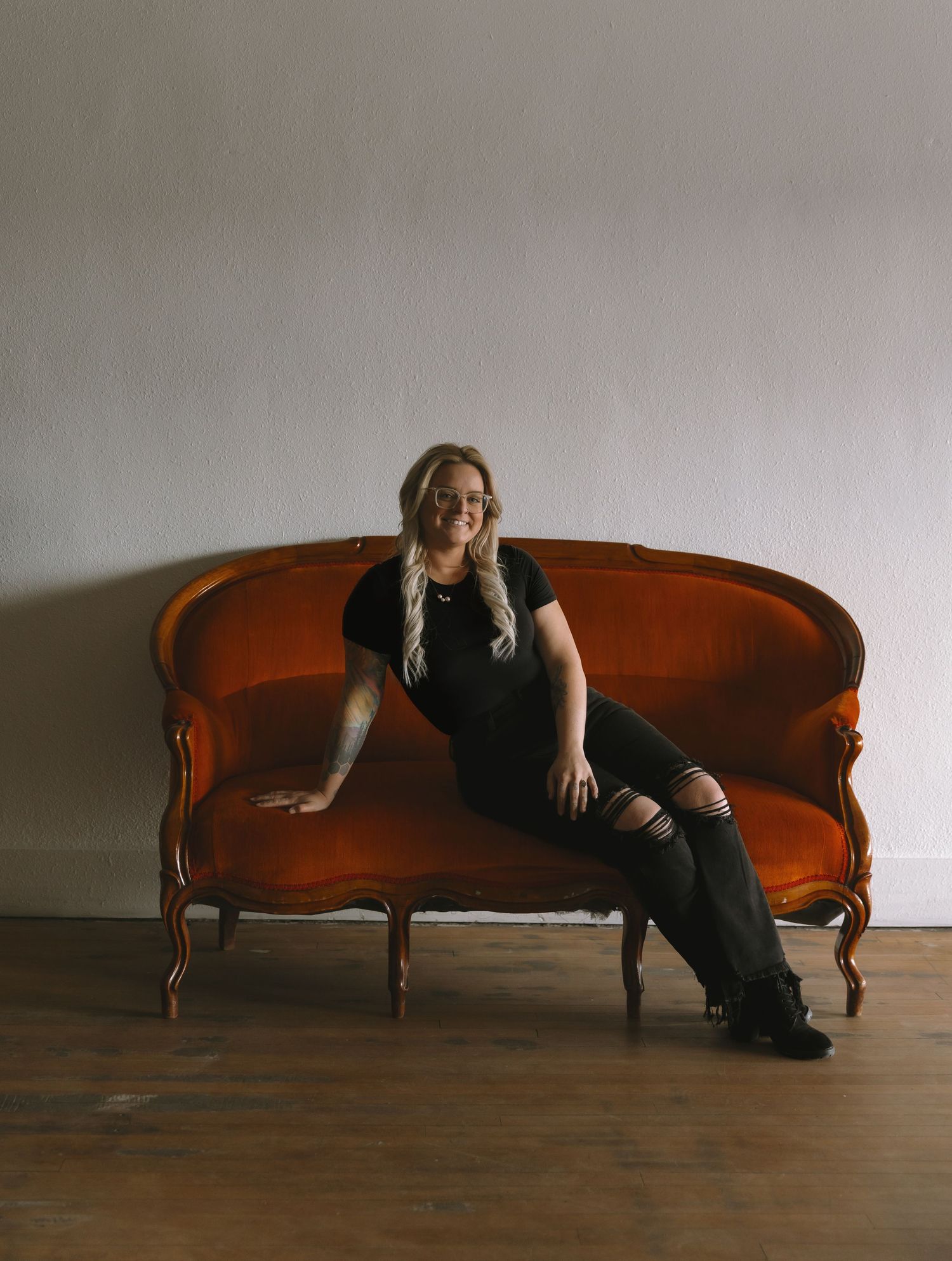 Bismarck, ND photographer sitting on couch in Poppy Creative who specializes in weddings, lifestyle, and boudoir photography