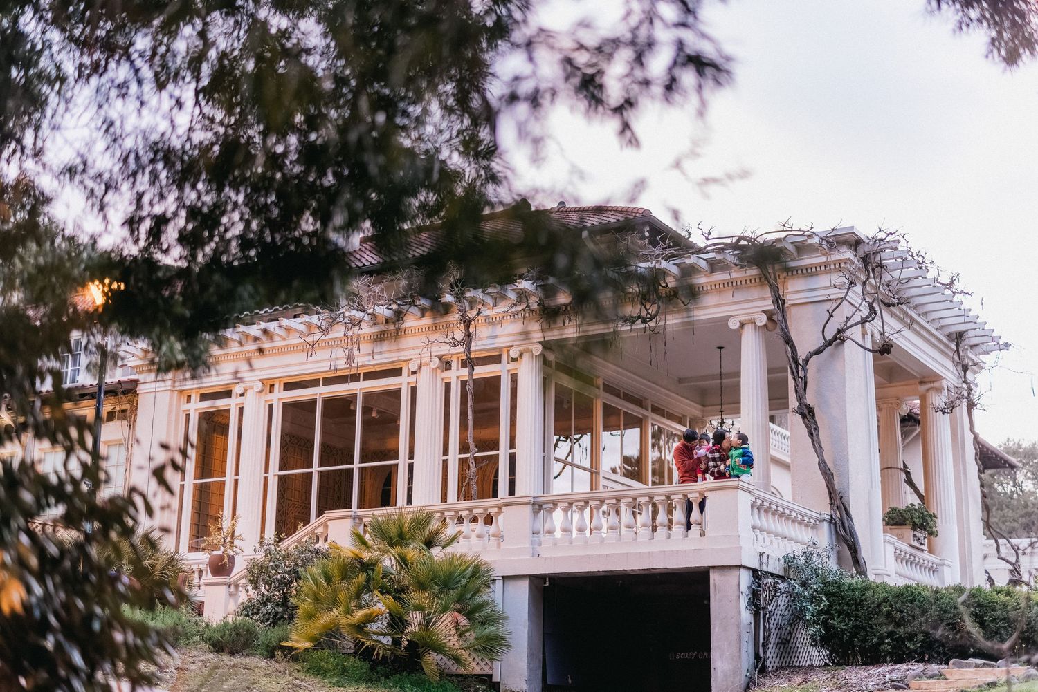 An elegant white mansion with Mediterranean architecture features grand columns and windows.
