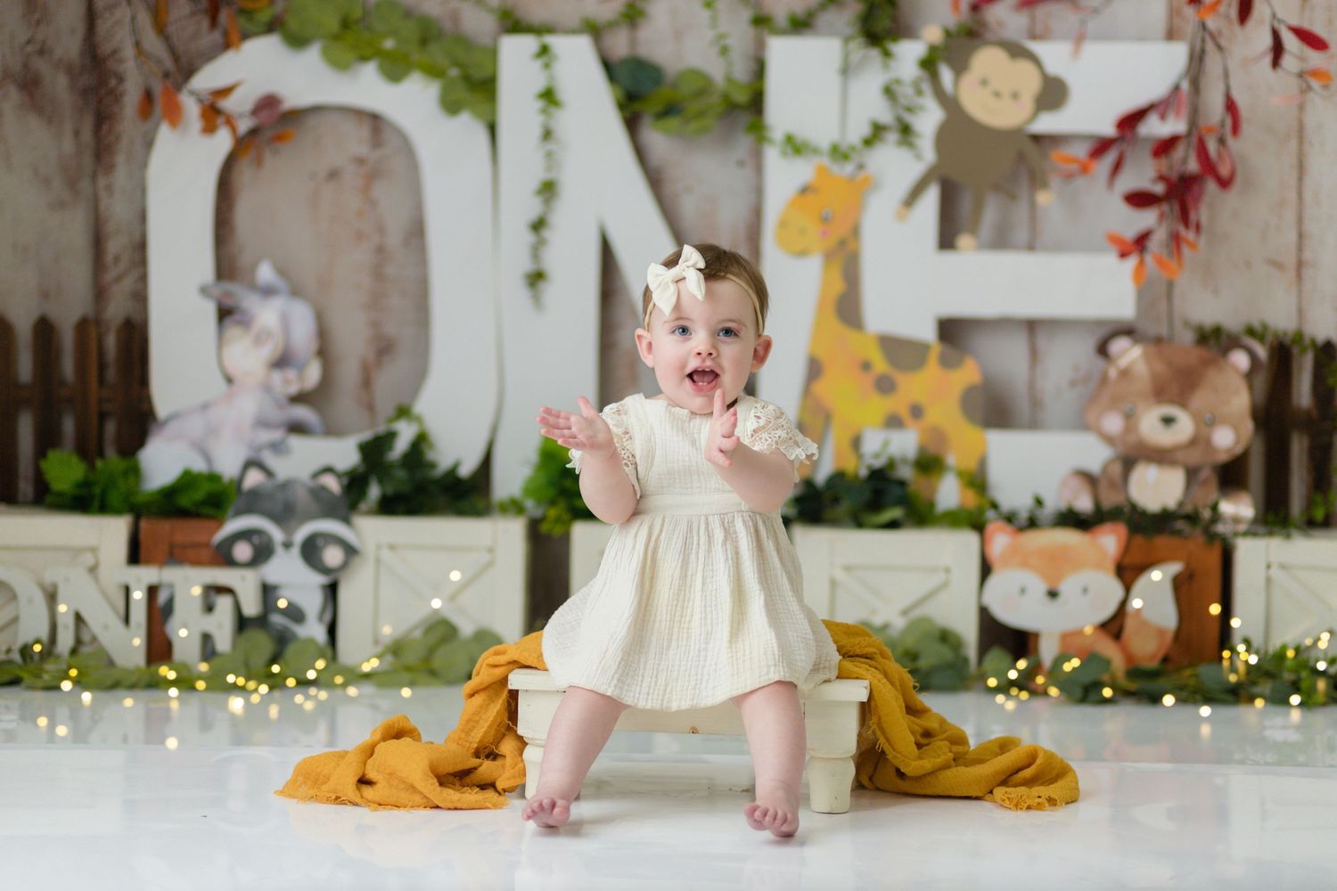 Safari themed photoshoot setup with giraffe, teddy bears and floral decorations.