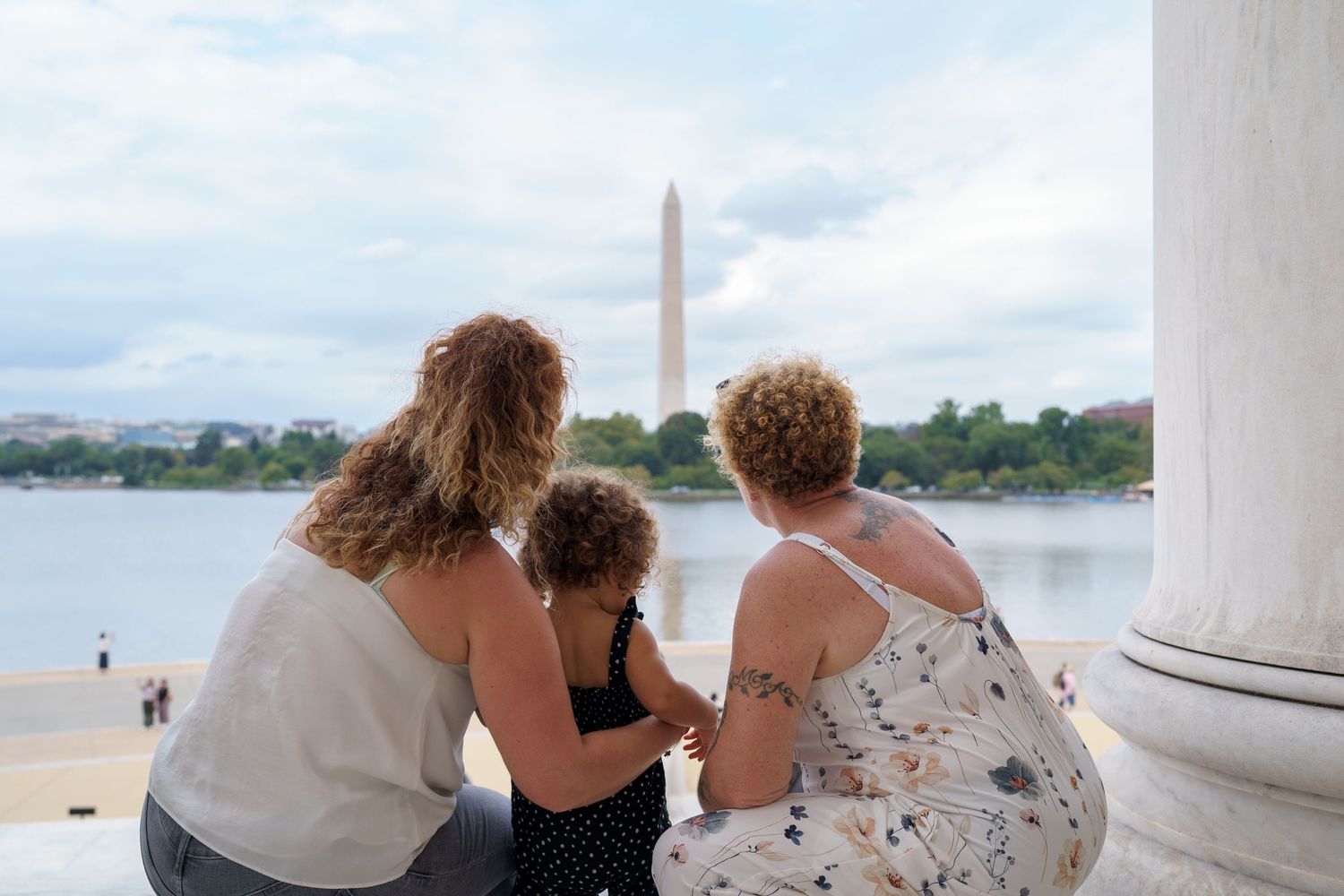 Family session overlooking the Washington Monument and Tidal Basin in Washington DC on a cloudy day.