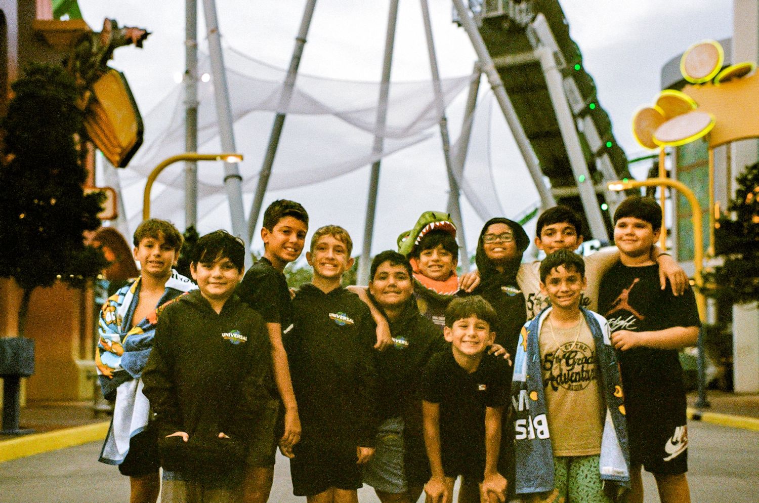Group wearing dark clothing poses together at a theme park attraction.