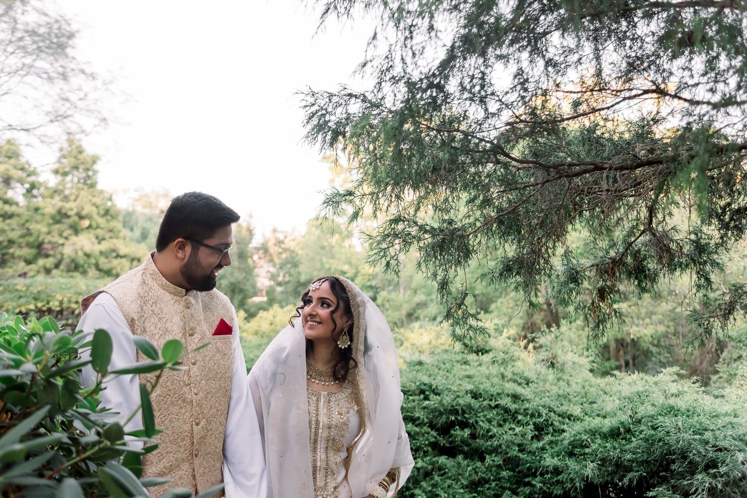 Rustic outdoor wedding photography session among evergreen trees.