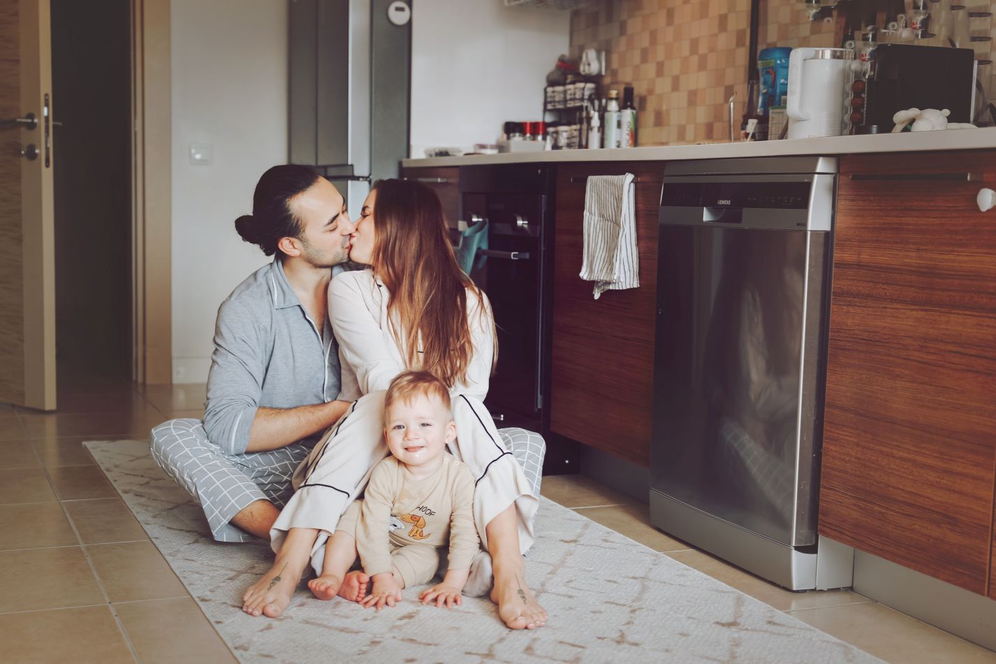 An intimate family moment captured in a modern kitchen setting.