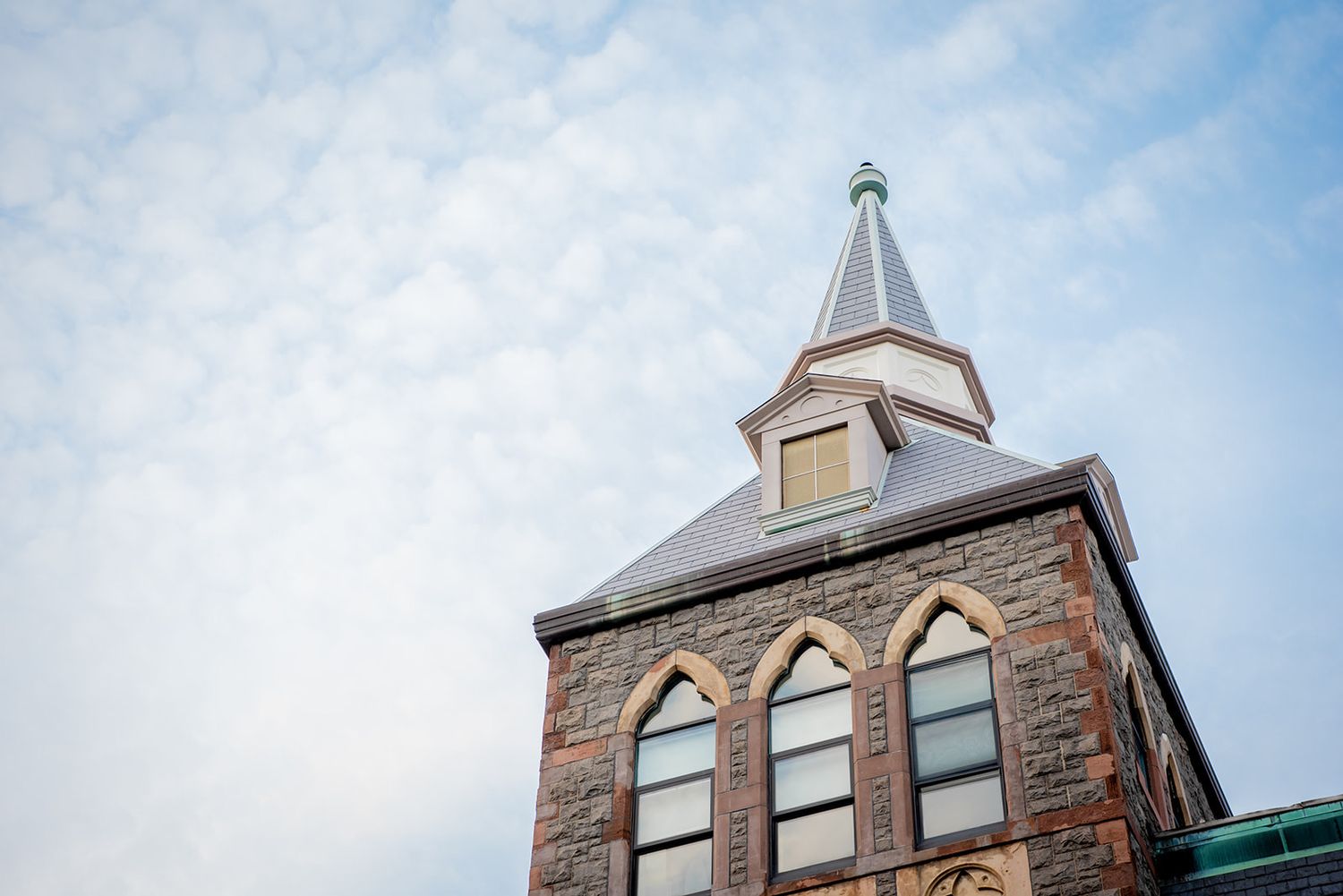 A row of historic church steeples and towers against a bright blue sky in an urban setting.