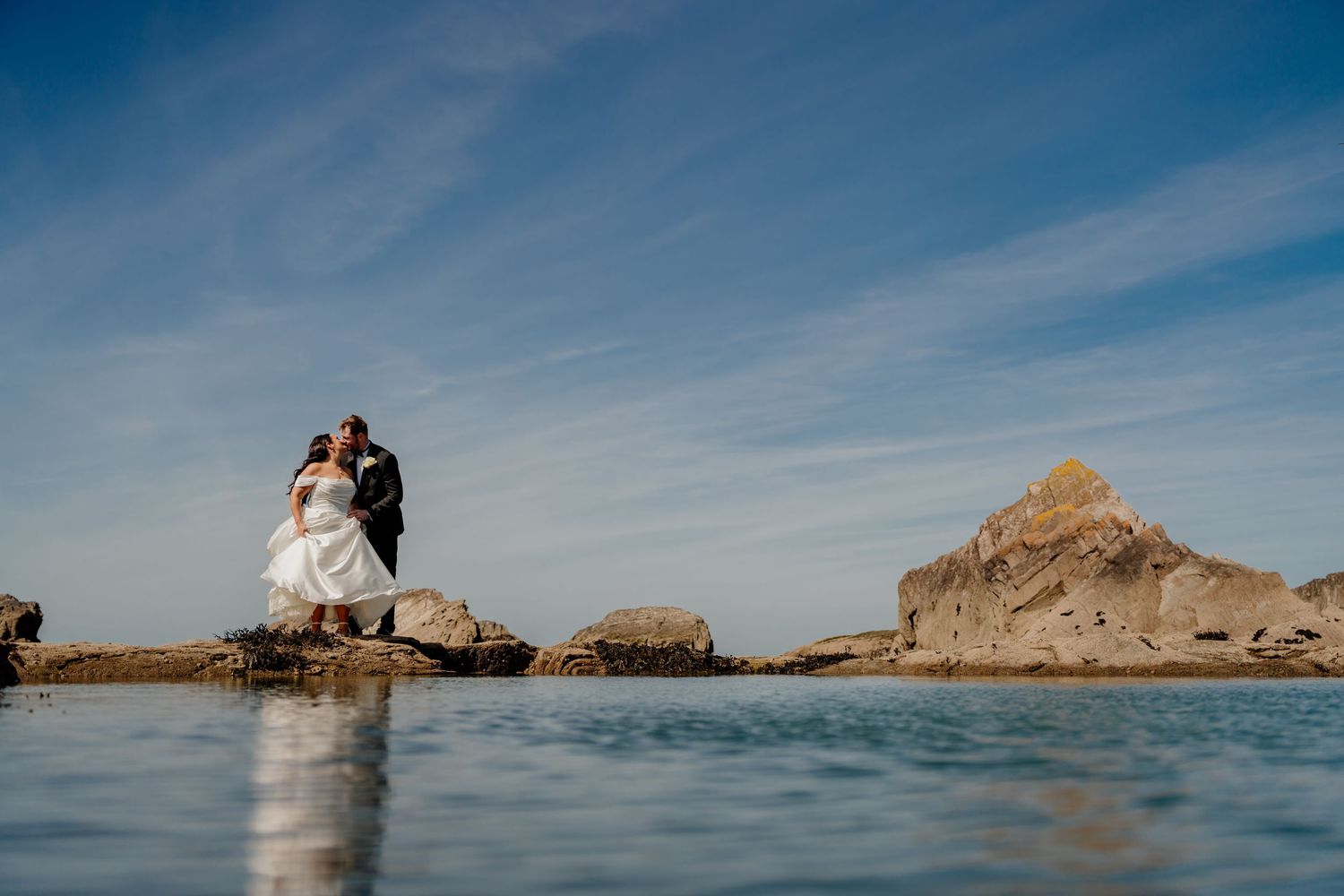 Silhouette of a couple standing on the tidal pool at tunnels beaches