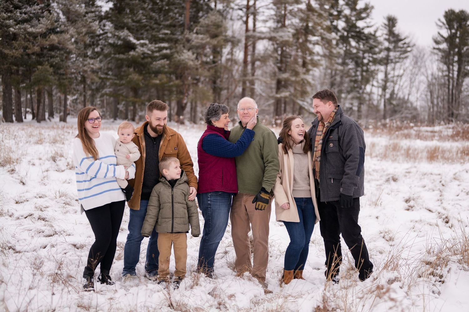 Family members lined up and walking together through a snow-covered winter setting.