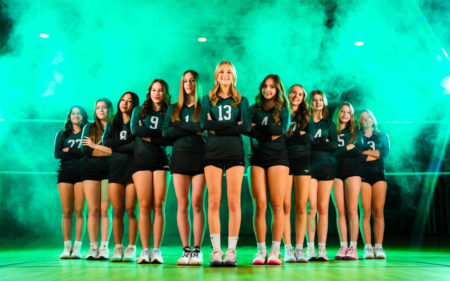 Full volleyball team lineup with dramatic green lighting and smoke effects
