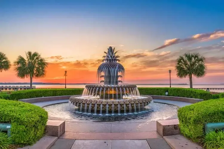The Pineapple Fountain at Charleston Waterfront Park glows during sunset as water cascades down its tiers.
