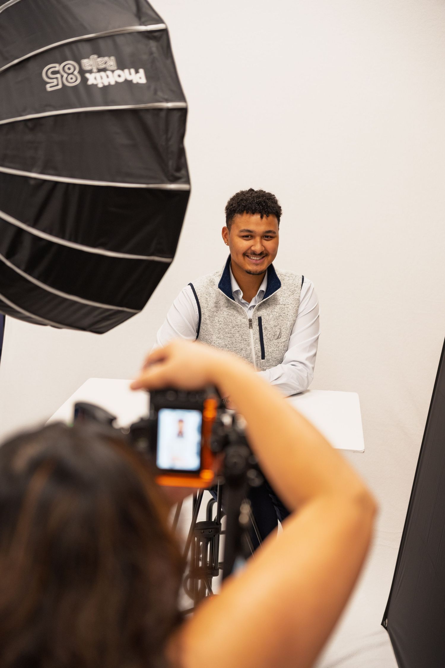 A selective focus photo showing multiple camera flashes and lighting equipment in a studio photoshoot setup.