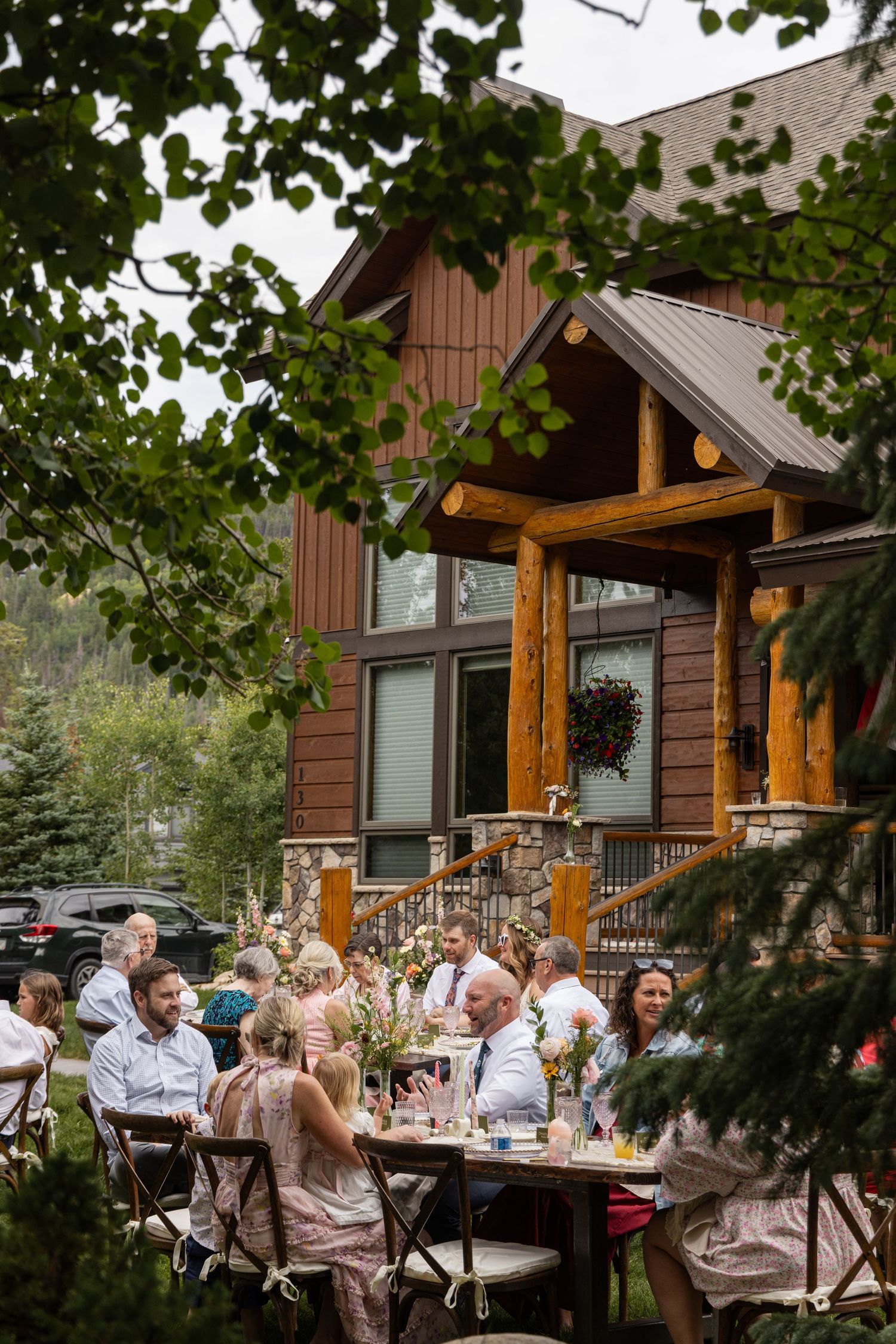 Outdoor wedding venue with rustic wooden elements and evergreen trees surrounding tables set up for dining in nature.