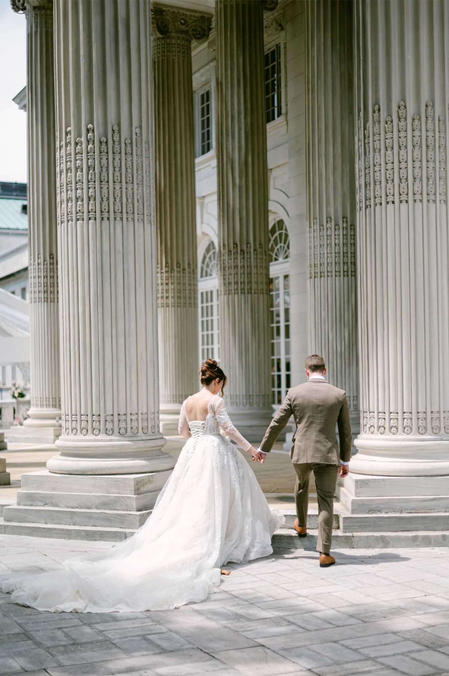 Just married couple embracing at elegant wedding venue with period artwork and windows at the DAR Constitution Hall in Washington DC.