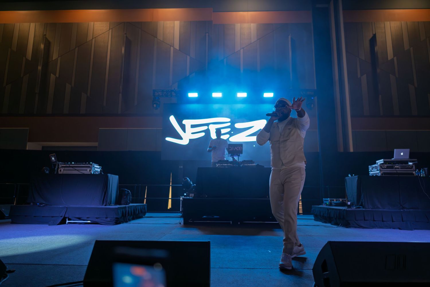 Concert performers on stage under dramatic blue lighting during a live music performance.