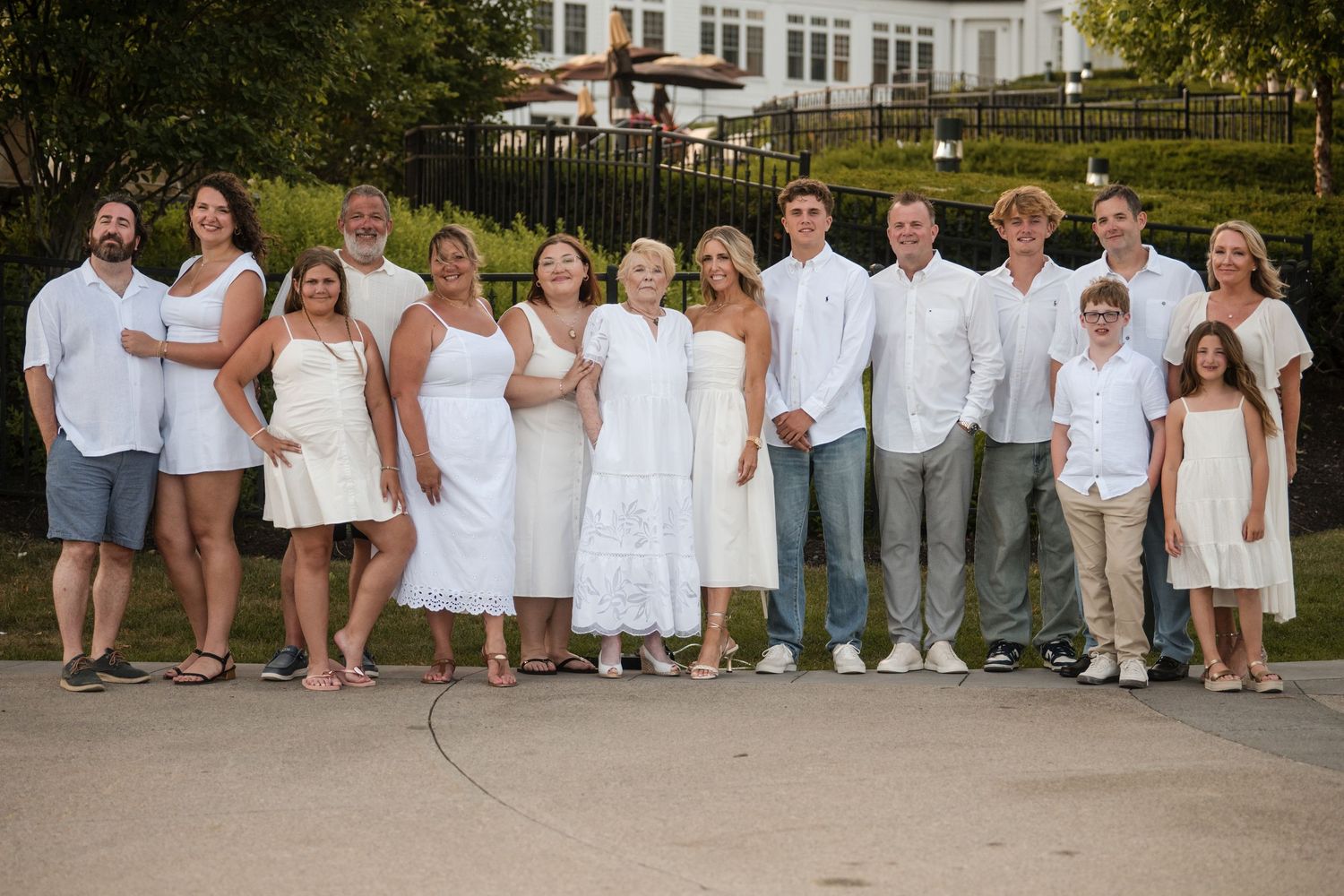 A panoramic collage of wedding party members in white and khaki attire posing outdoors for group photos.