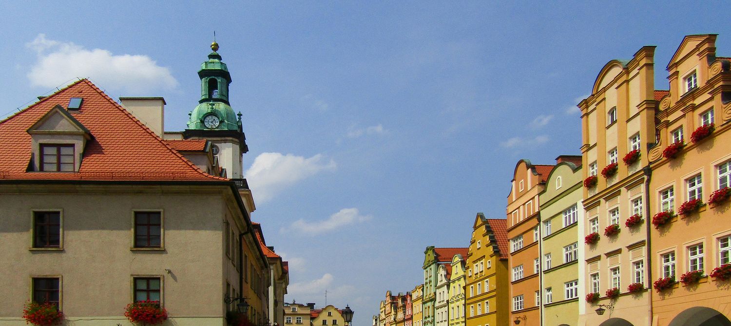 Jelenia Gora town center, view of town hall clock tower and colorful row of brownstone type buildings and homes.