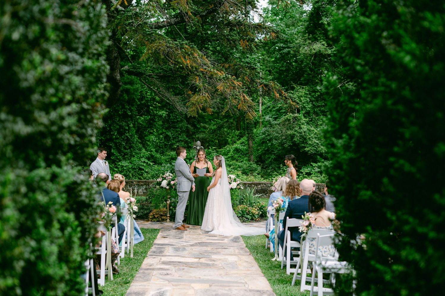 A Rust Manor House wedding party enjoying a warm summer celebration in a lush green garden setting with festive decorations.