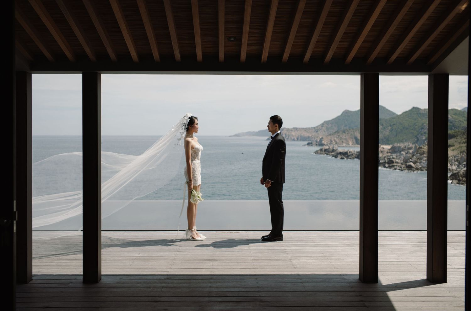Couple walking apart from each other at opposite ends of a wooden deck overlooking a serene mountain lake view.