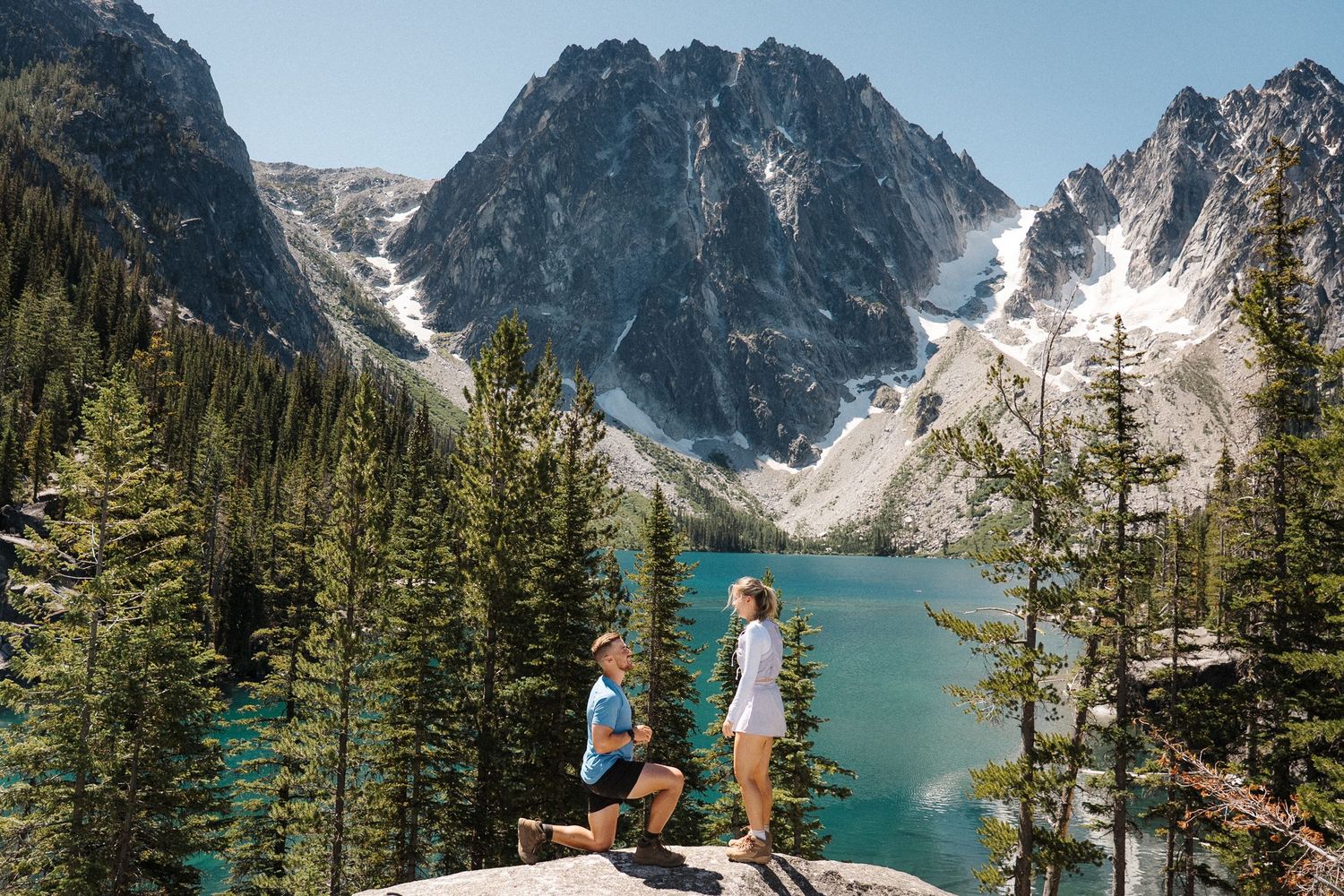 A majestic mountain lake surrounded by snow-capped peaks and evergreen forest in Colchuck Lake, Washington.
