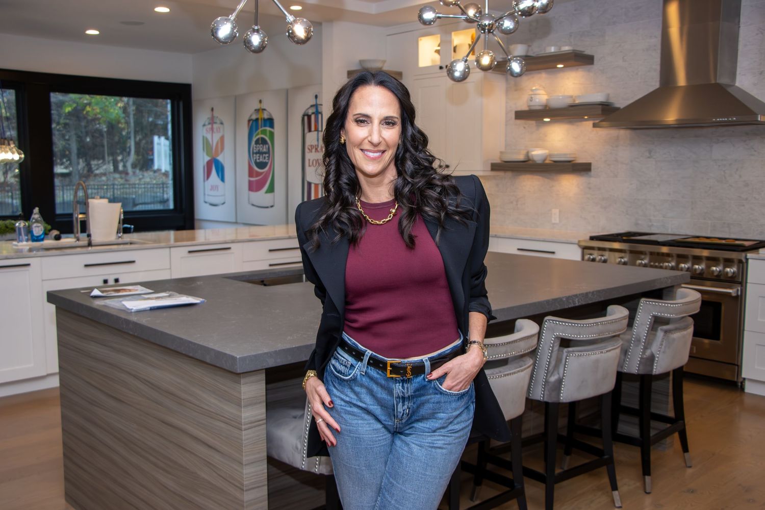 Modern open concept kitchen with white cabinets, island seating, and elegant pendant lighting fixtures.