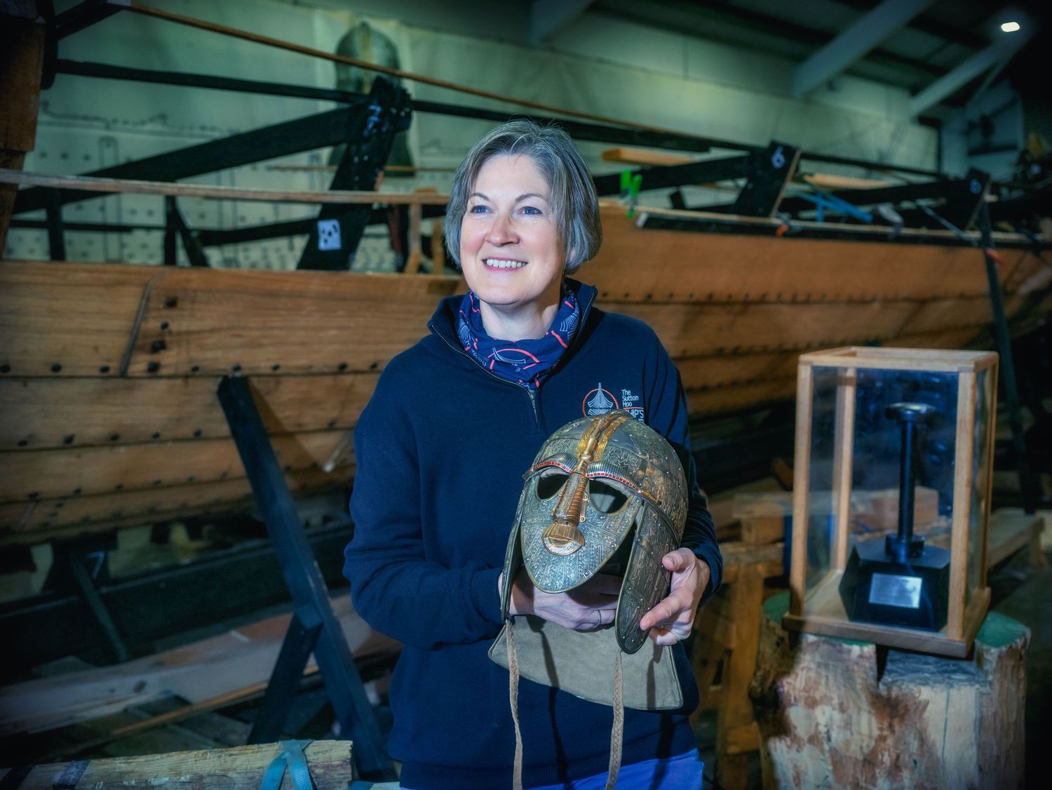 Sutton Hoo Longshed portrait of Helen Geake holding a Saxon mask during the longboat build, Woodbridge, Suffolk