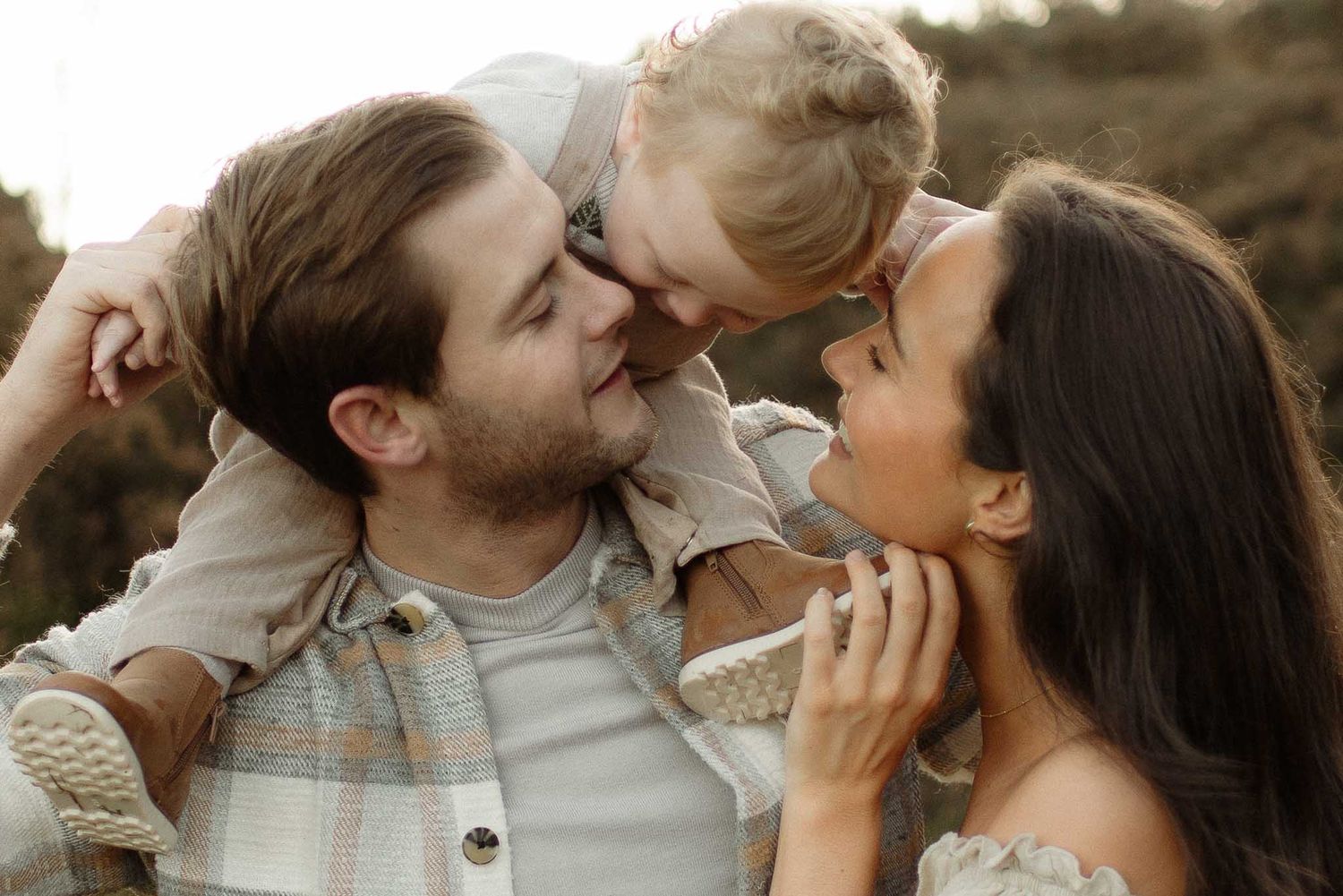 A loving family shares a tender outdoor moment together during sunrise during family photoshoot at Healey Nab, Chorley