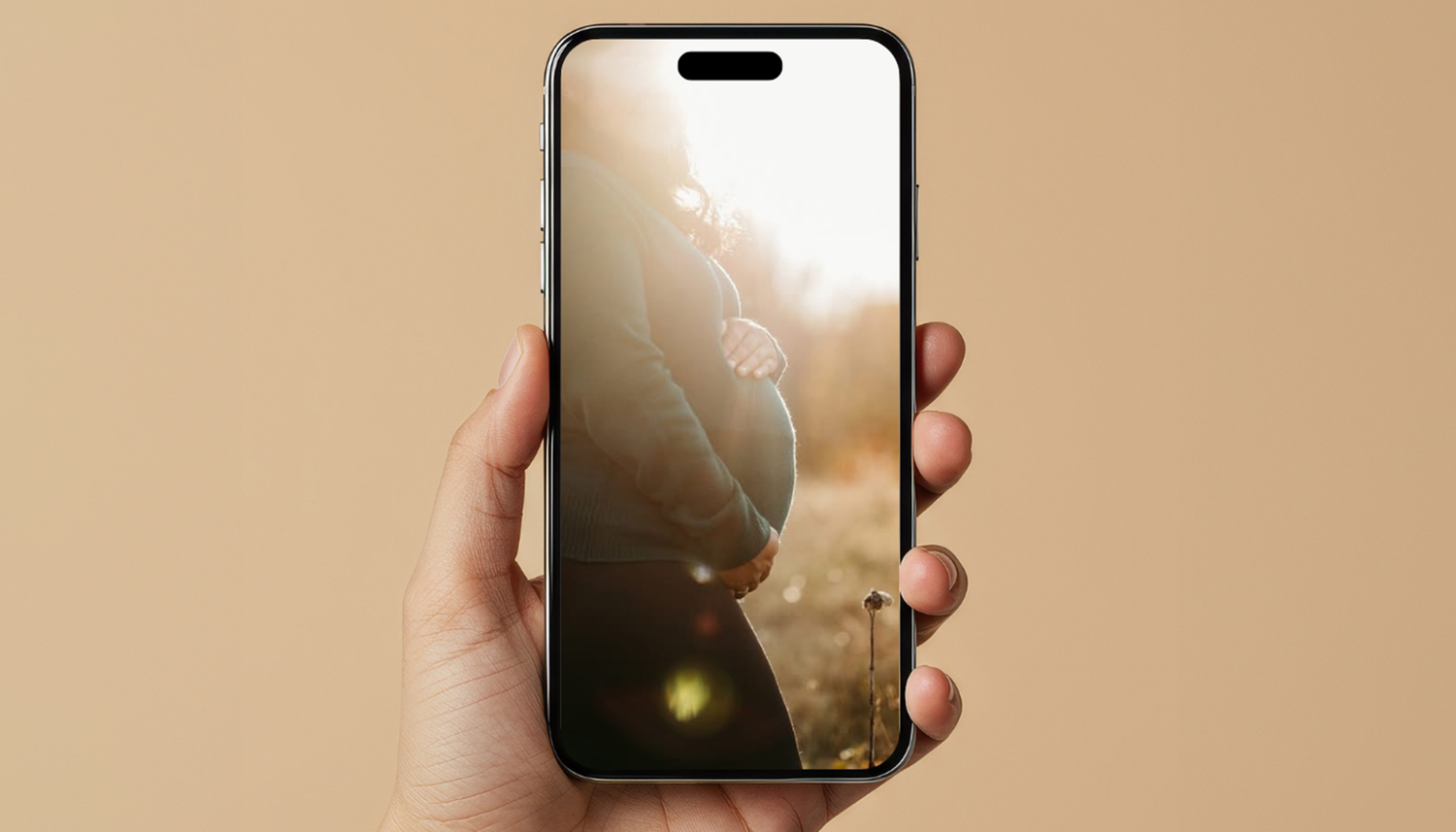 Hand holding an iPhone displaying a moody atmospheric photo with lens flare against a beige background.