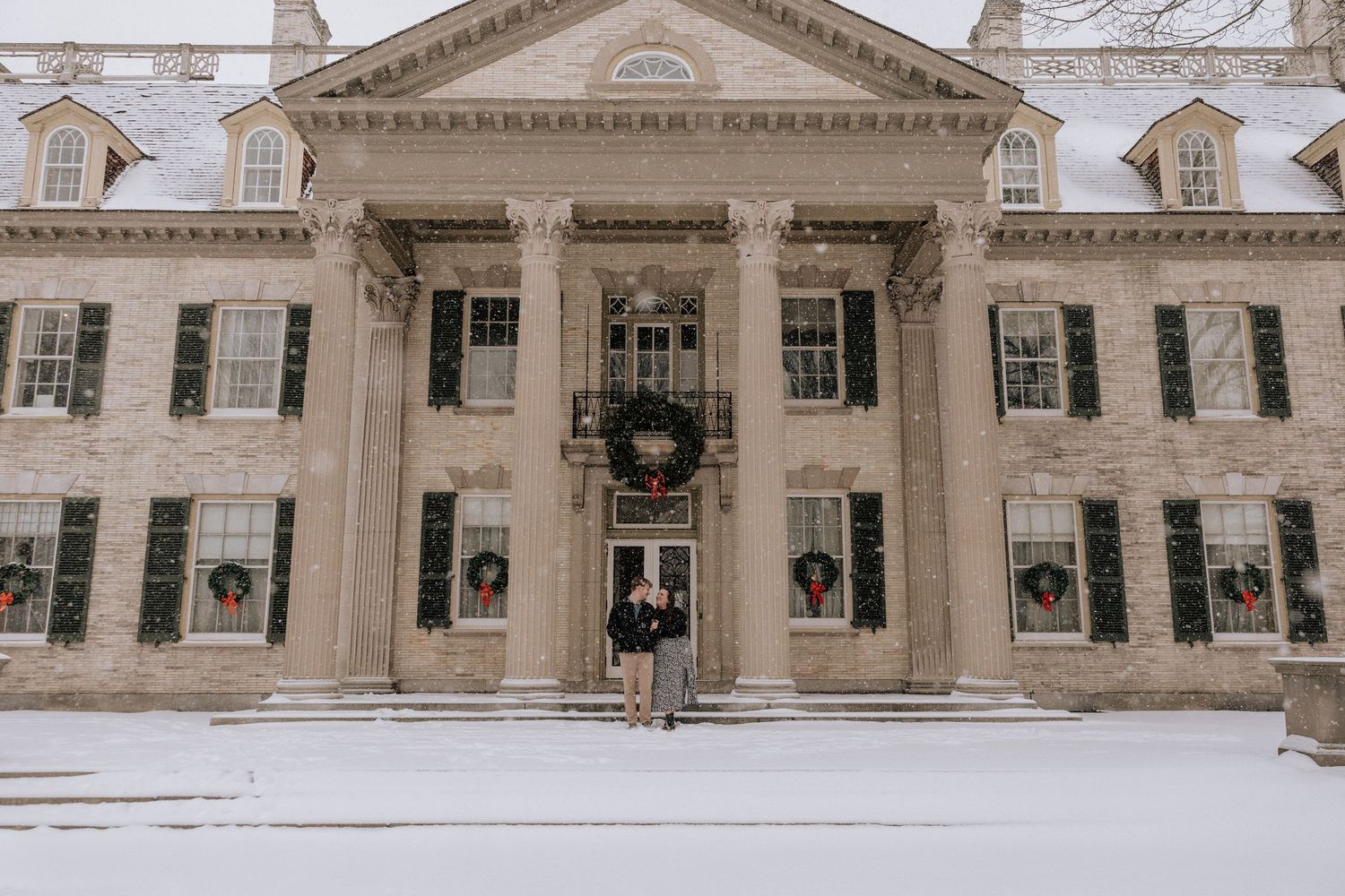 Exterior view of a historic government building with classical architecture and holiday wreaths on the windows.