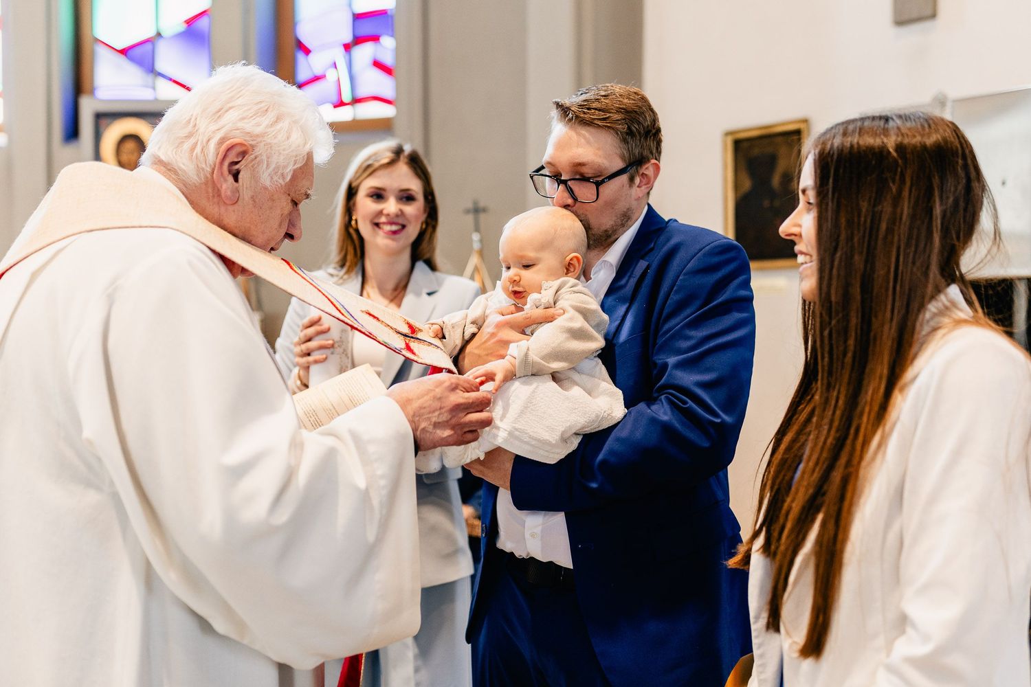 Baby wird im Kreise ihrer Familie in der Kirche getauft.