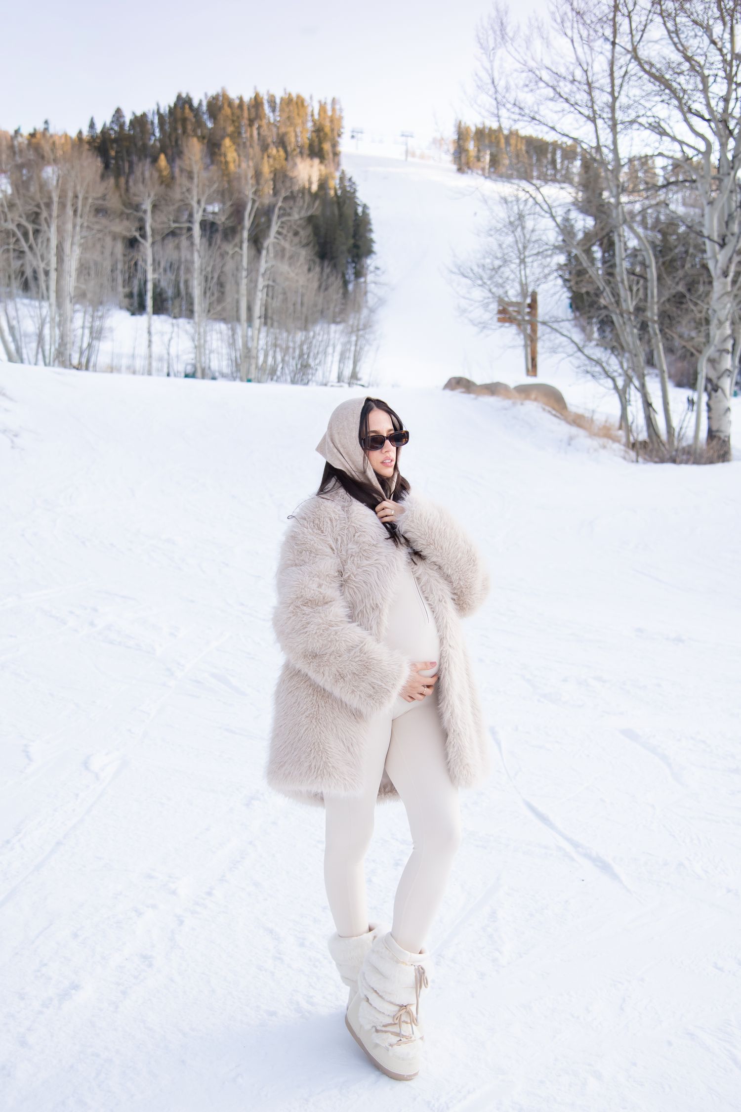 Fashionable woman in cute stylish outfit for her winter maternity photo session in Vail Colorado