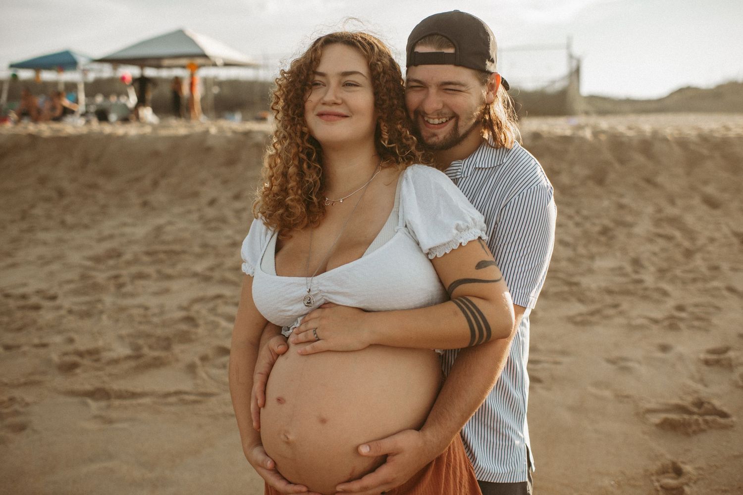 Virginia Beach expecting couple posing for their maternity session at their favorite part of the beach.