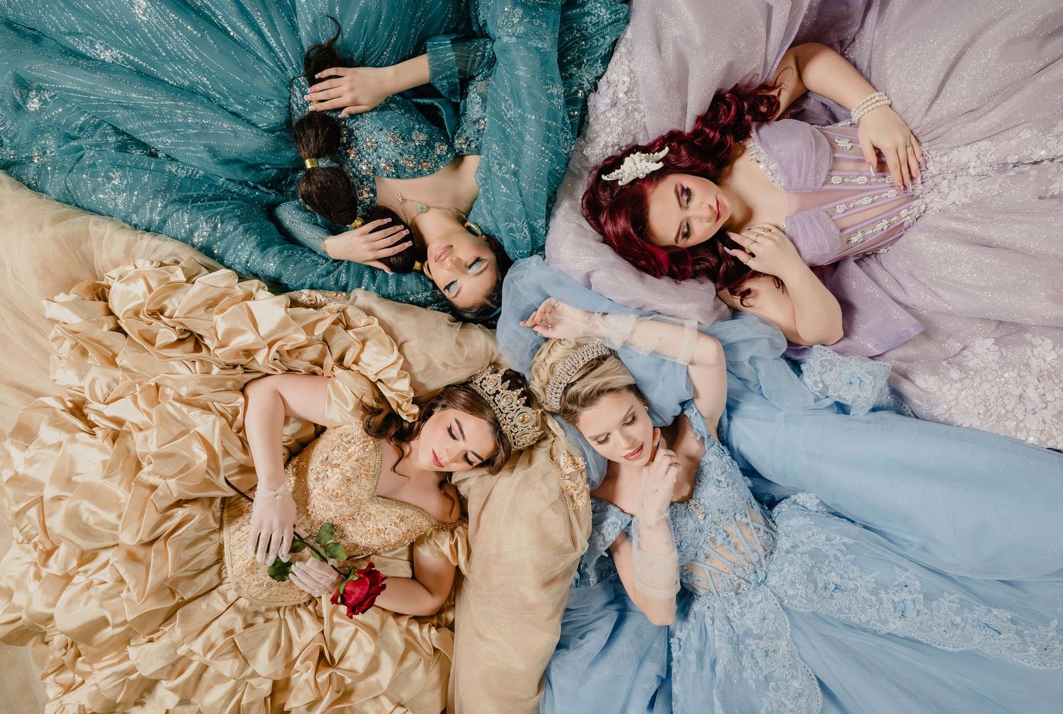 Top down photograph on Disney quinceanera princesses. Jasmine, Belle, Ariel and Cinderella.