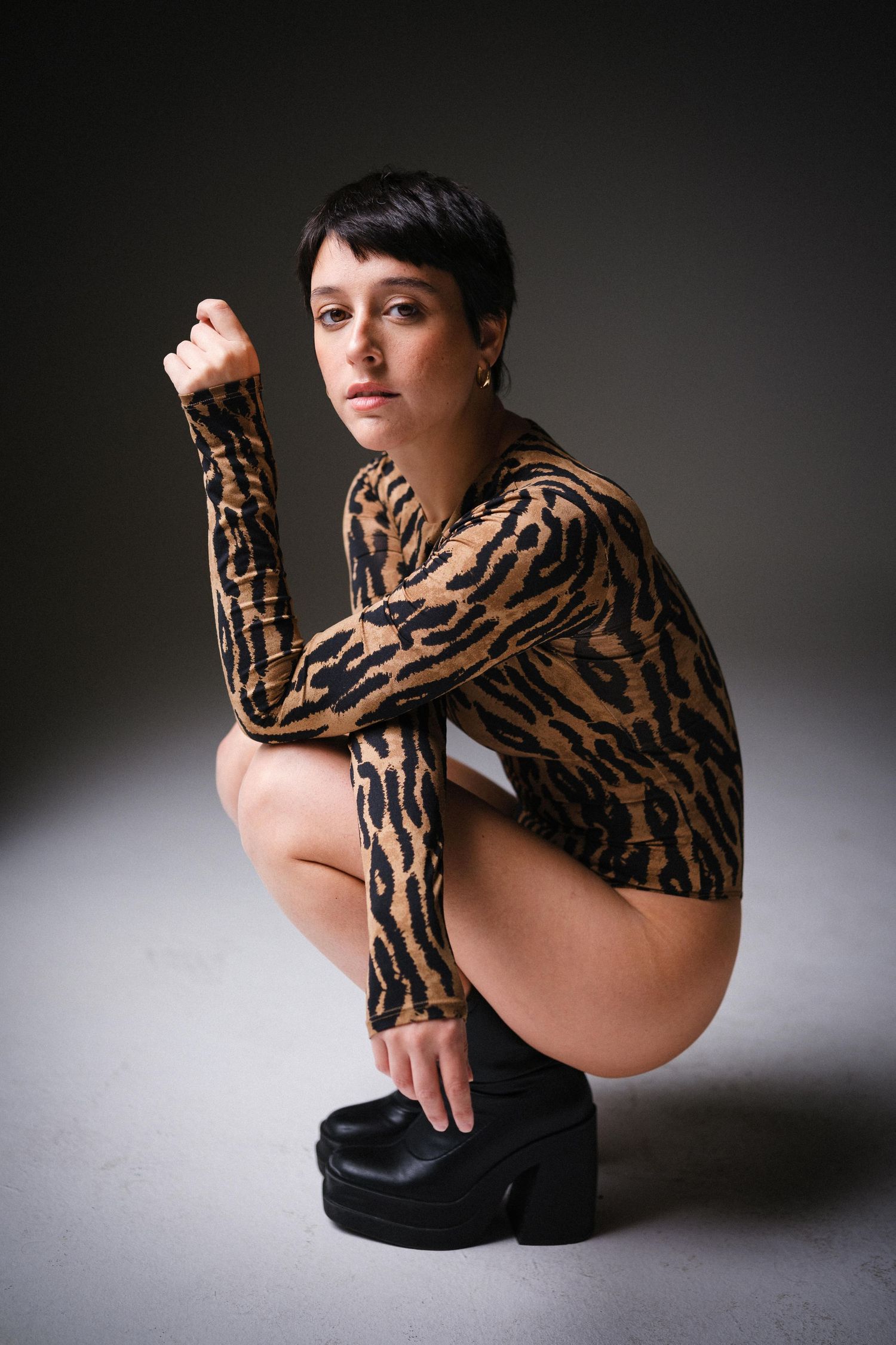 Artistic fashion photograph showing model in animal print clothing with dramatic shadows.